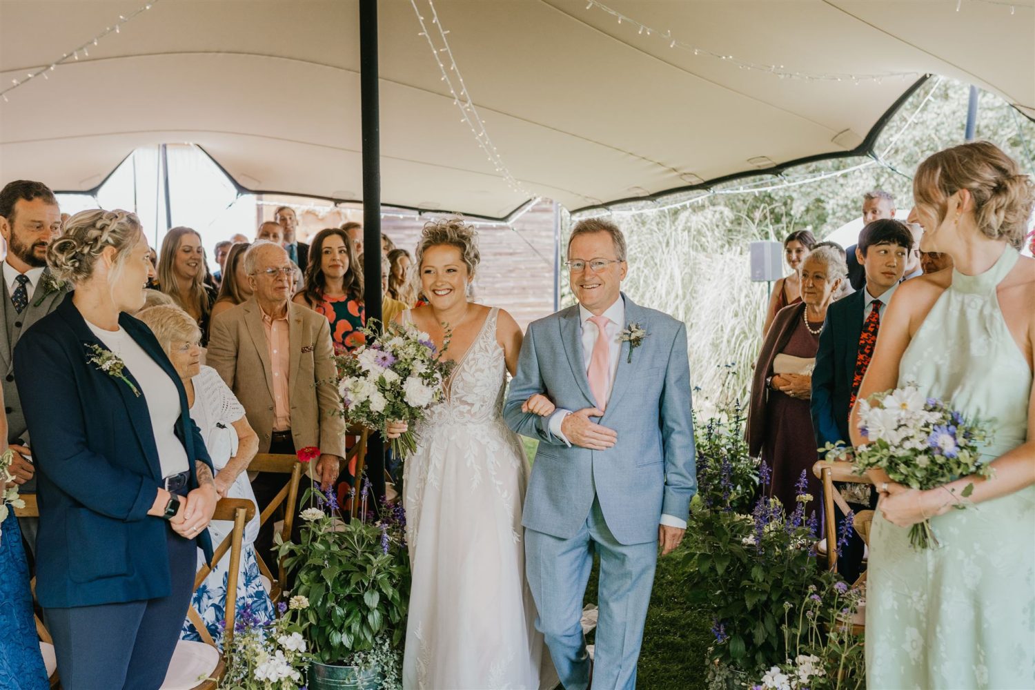 bride walks down the aisle with father at acorn barn wedding ceremony