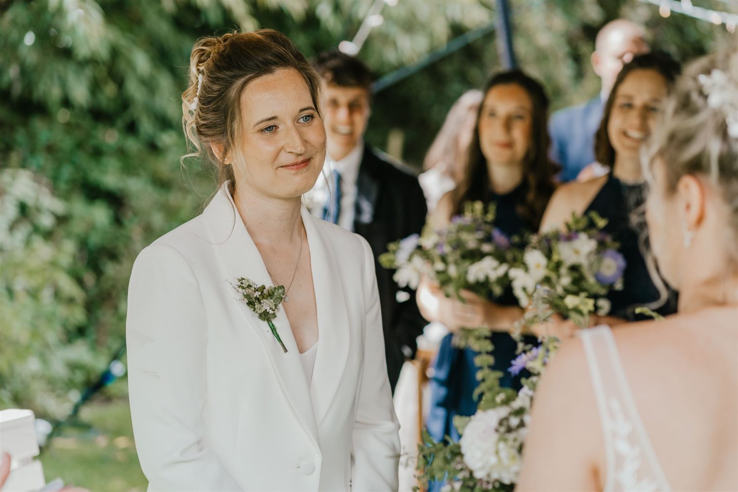brides looking at each other during outdoor wedding ceremony at acorn barn wedding venue in oxfordshire