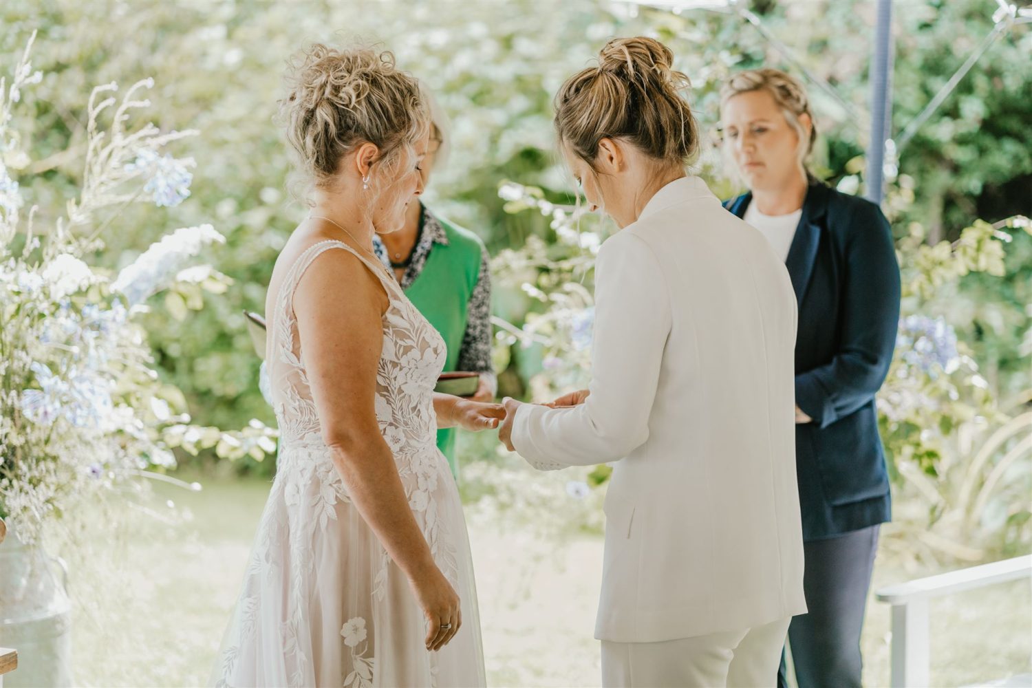 brides exchange rings during garden ceremony at acorn barn wedding venue in oxfordshire