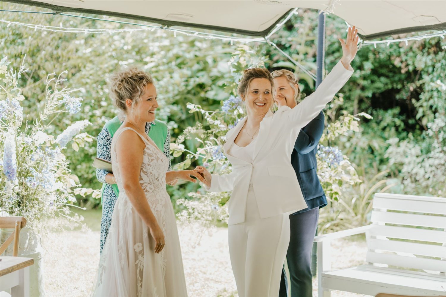 brides exchange rings during garden ceremony at acorn barn wedding venue in oxfordshire