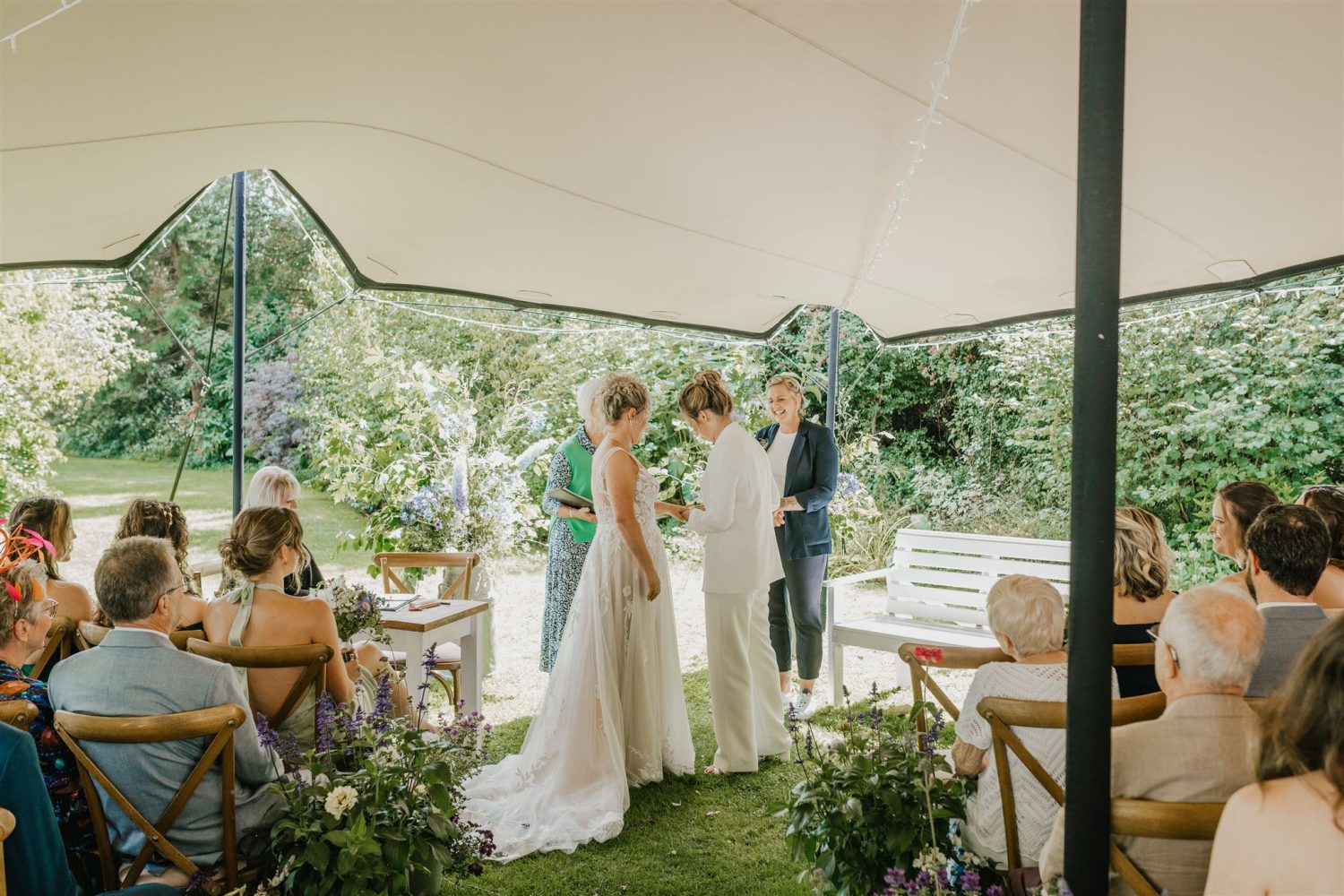 brides exchange rings during garden ceremony at acorn barn wedding venue in oxfordshire