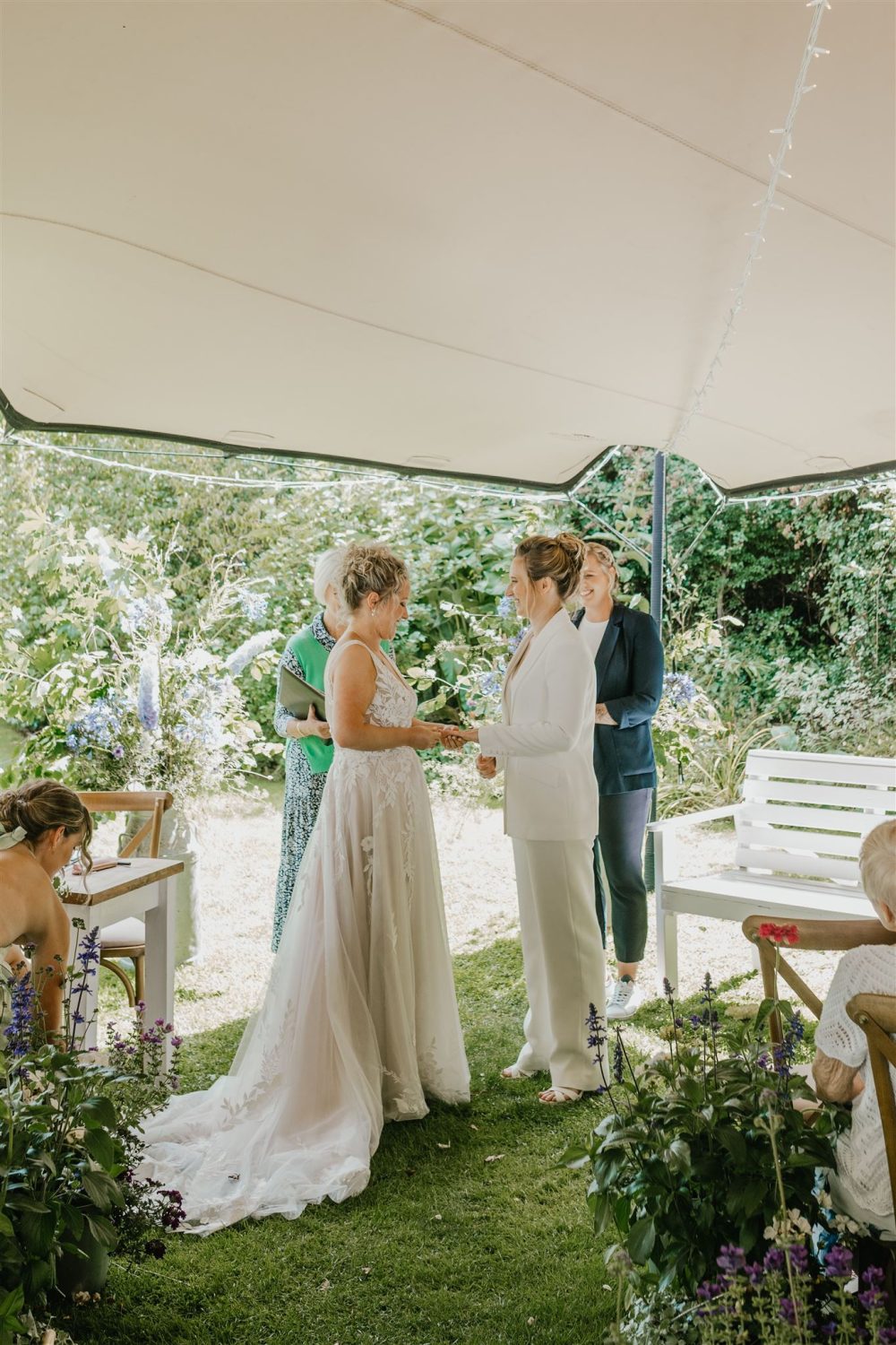 brides exchange rings during garden ceremony at acorn barn wedding venue in oxfordshire