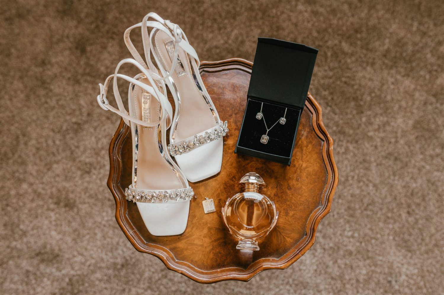 bride's shoes, jewellery and perfume on an antique table