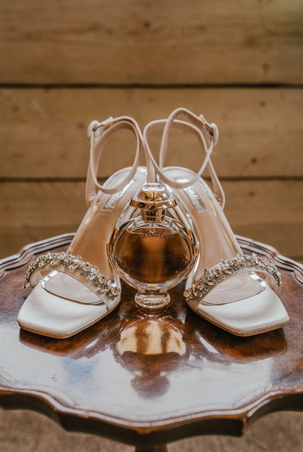 bride's shoes and perfume on an antique table