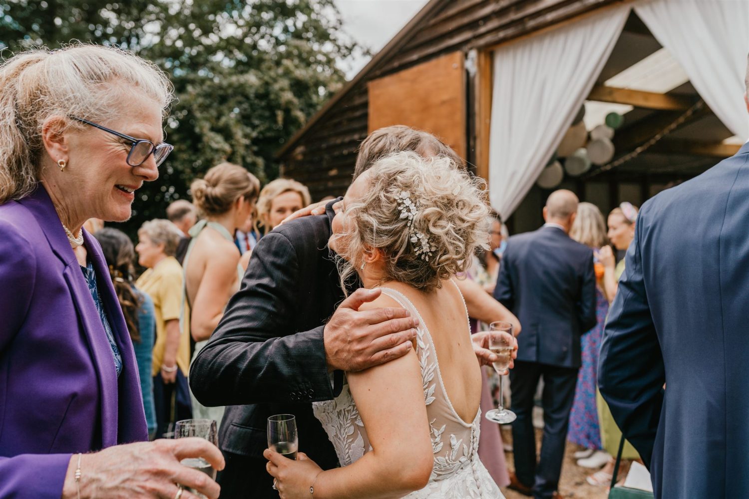 bride greets wedding guests during wedding drinks reception