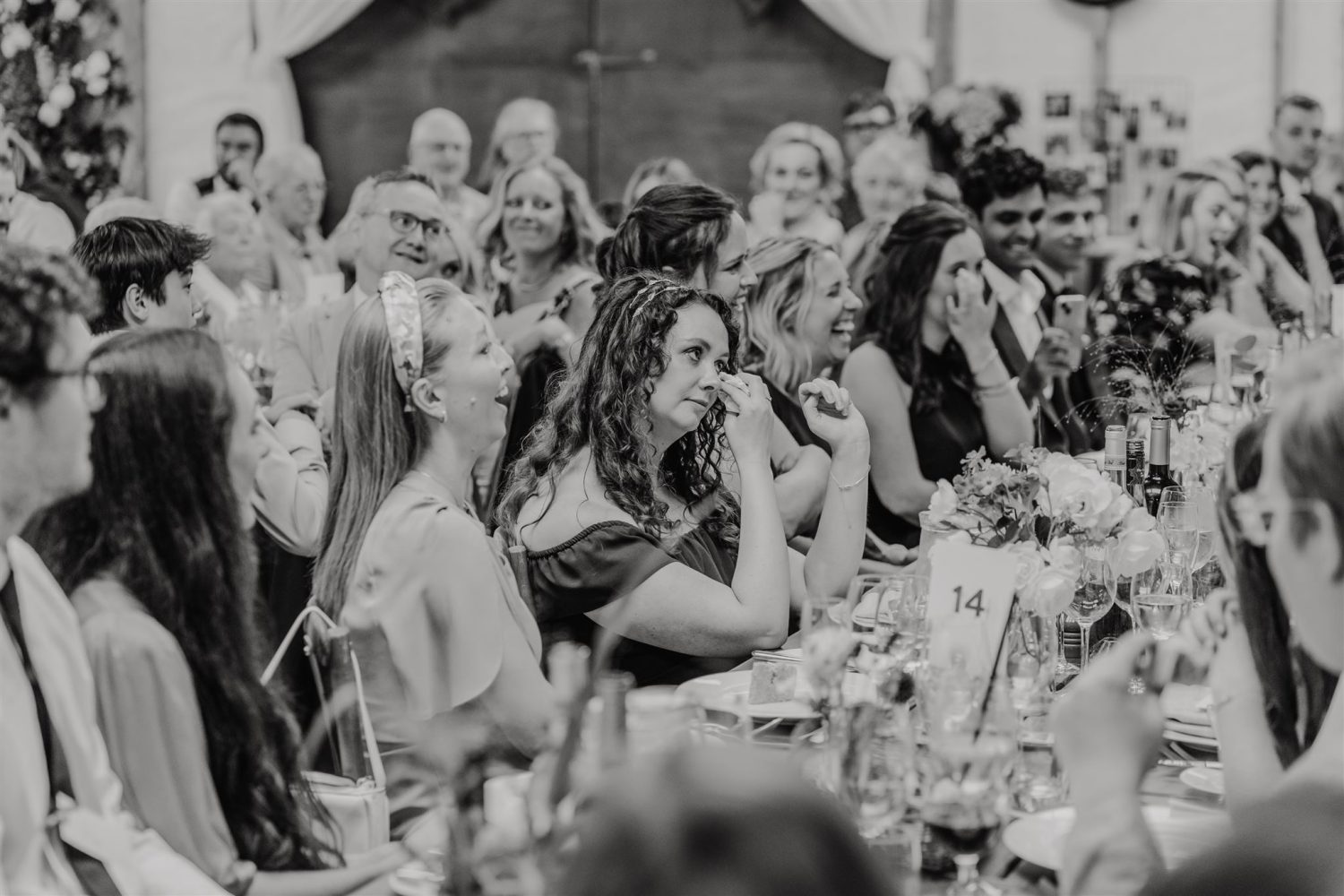 black and white photo of guest's reaction to bride's speech at acorn barn wedding venue