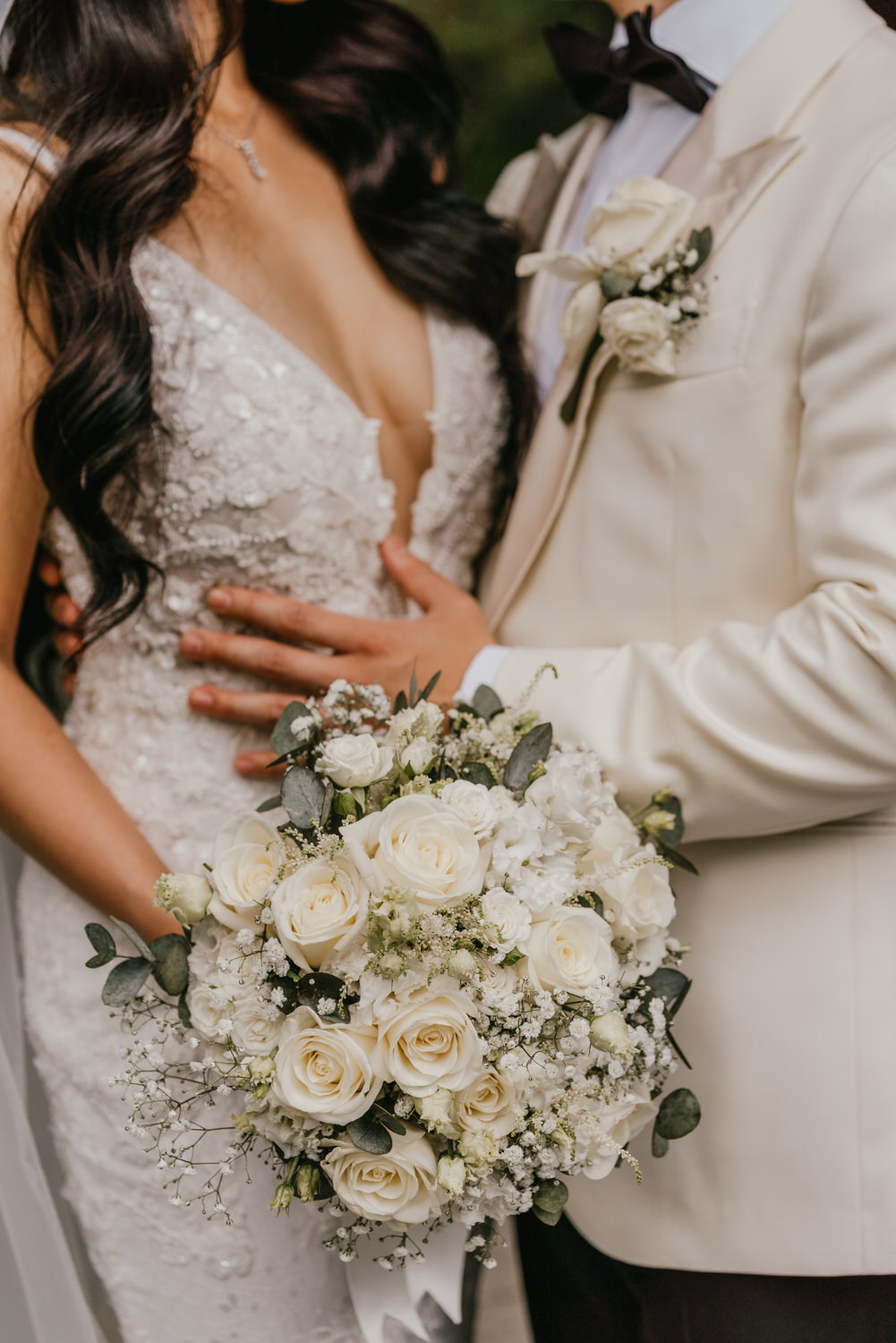 detail shot of bride and groom with wedding bouquet