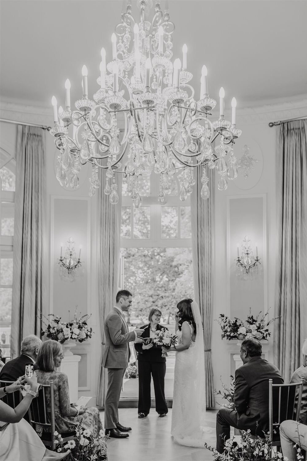 black and white photo of groom reading vows during wedding ceremony in the loggia at mandarin oriental hyde park luxury wedding venue in london