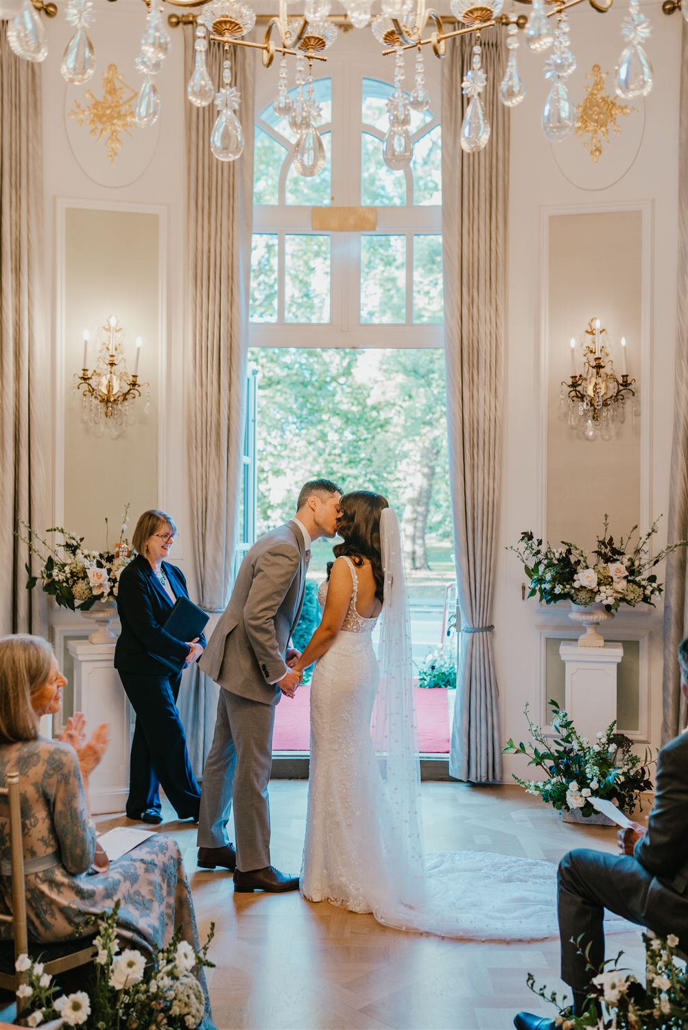 bride and groom first kiss during wedding ceremony in the loggia at mandarin oriental hyde park luxury wedding venue in london