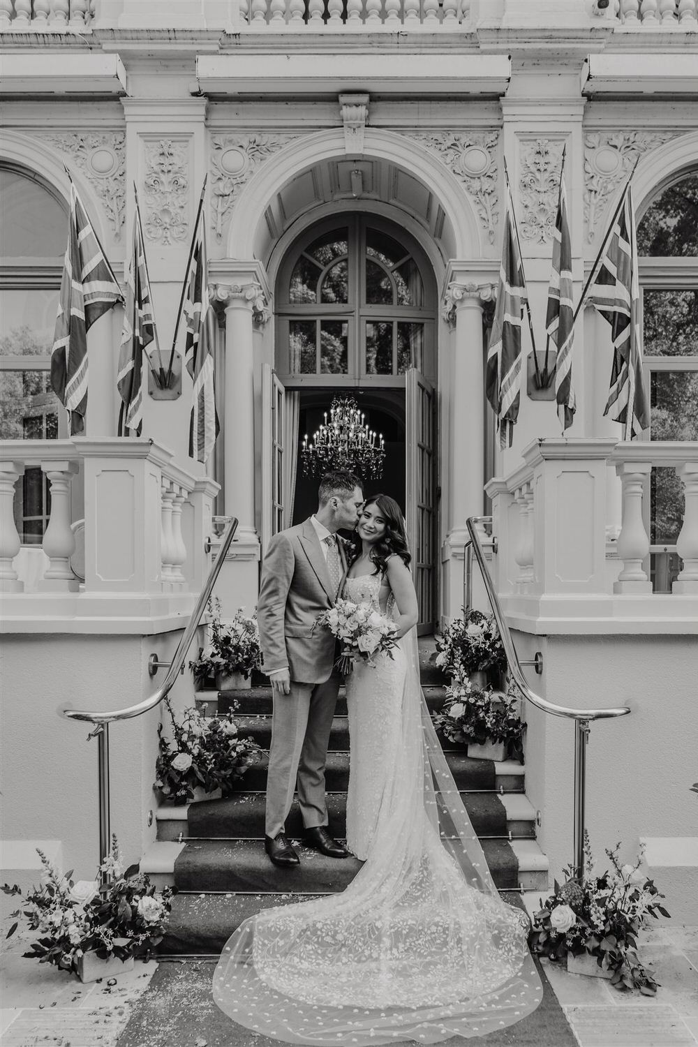 black and white couple portrait on the steps outside mandarin oriental hyde park luxury wedding venue in london
