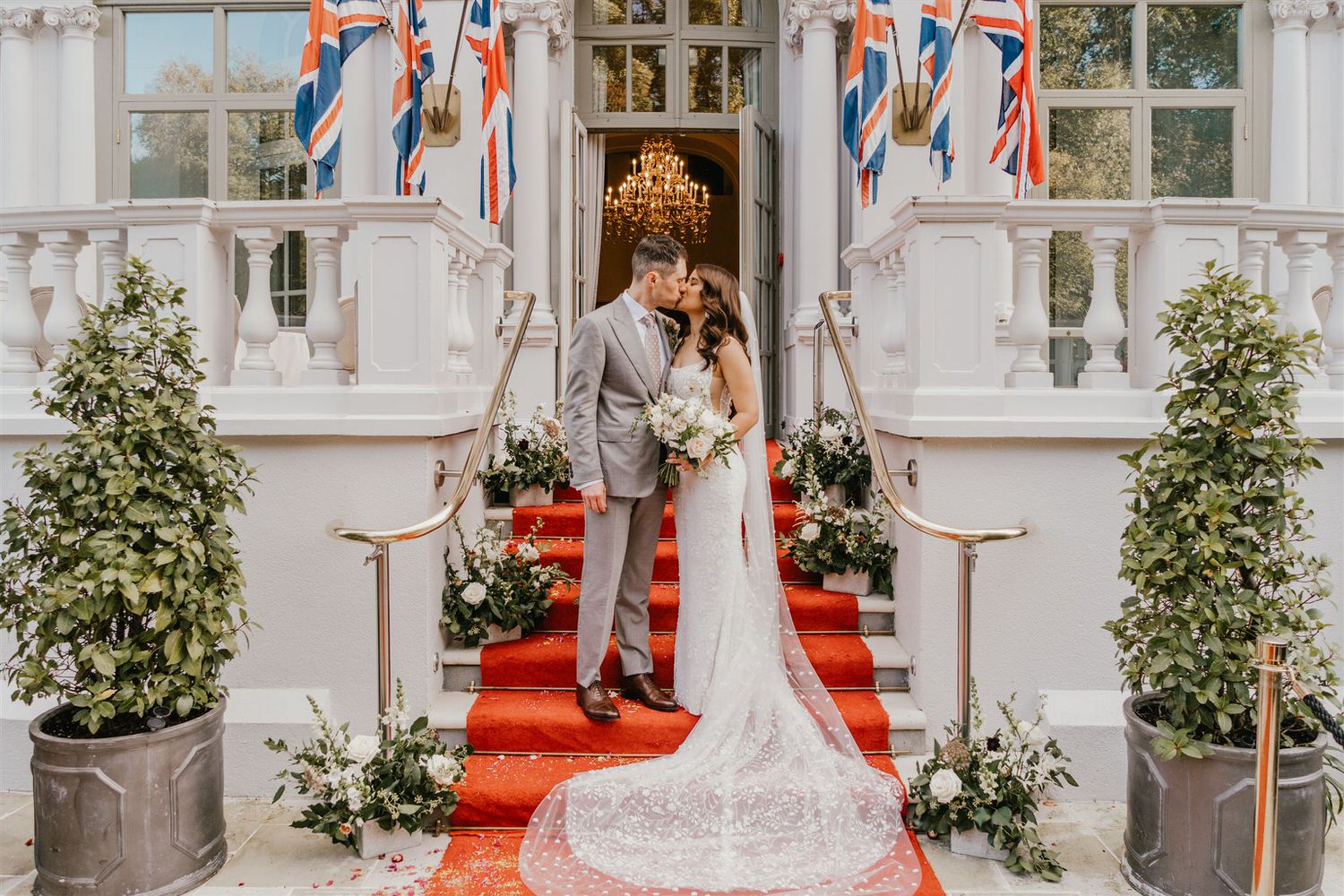 bride and groom kiss on the steps outside mandarin oriental hyde park luxury wedding venue in london