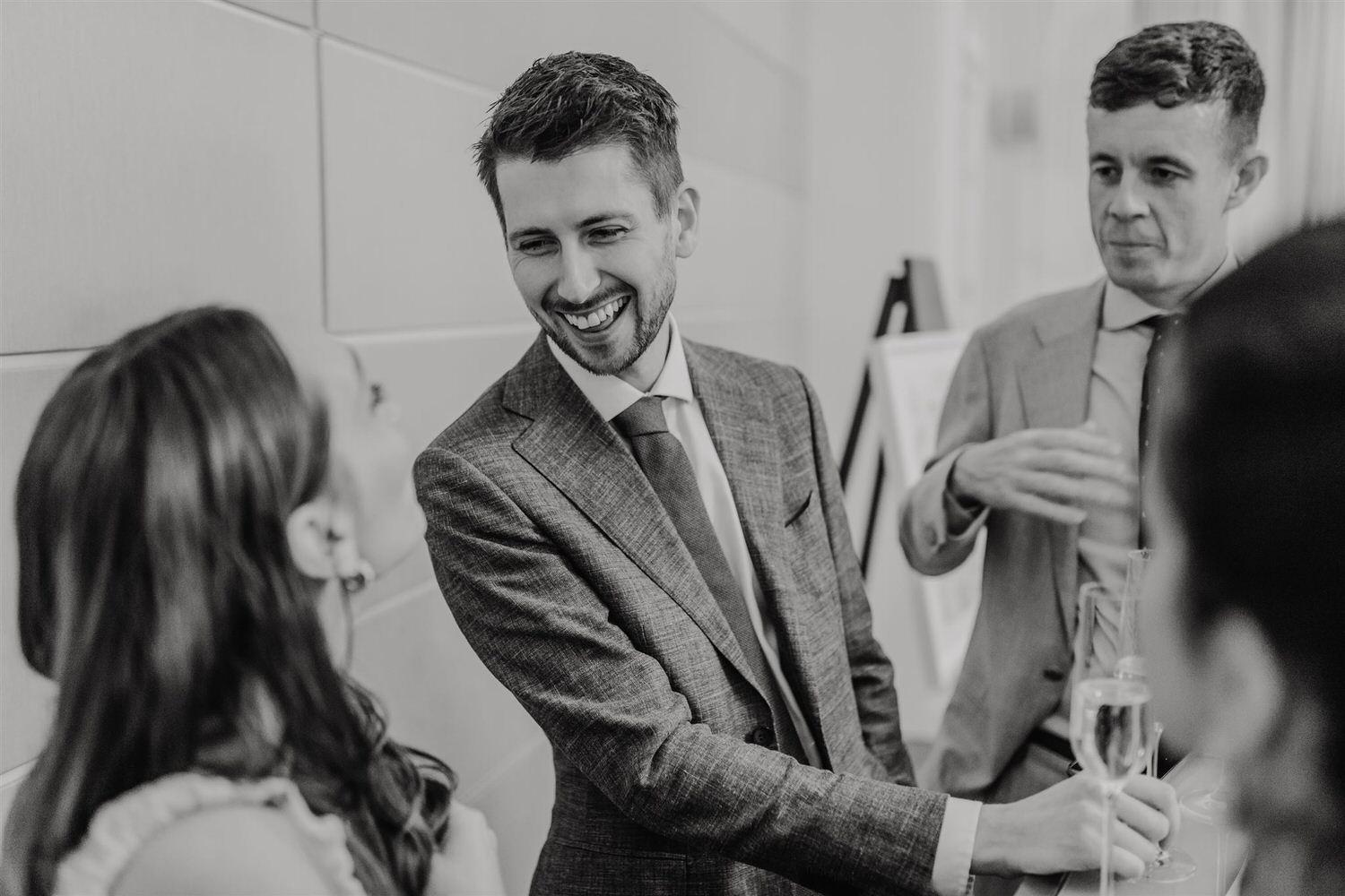 black and white photo of guest laughing during cocktail hour at intimate mandarin oriental wedding london