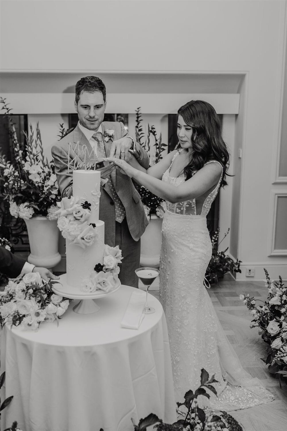 black and white photo of bride and groom cutting wedding cake at mandarin oriental wedding london