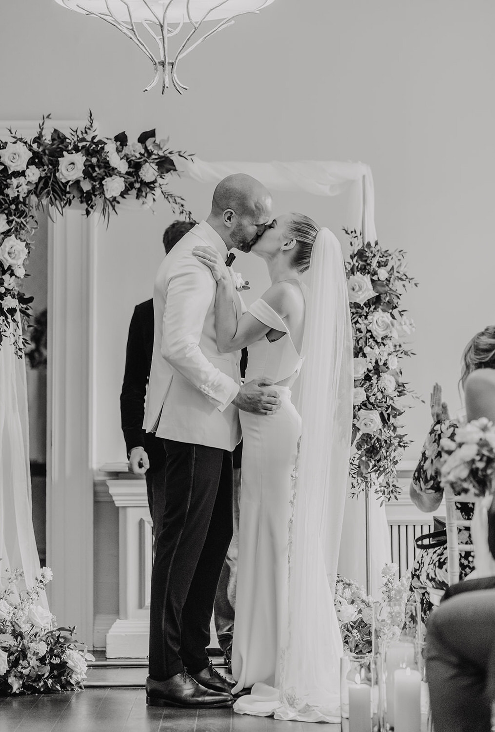 black and white photo of bride and groom first kiss during london wedding ceremony at morden hall