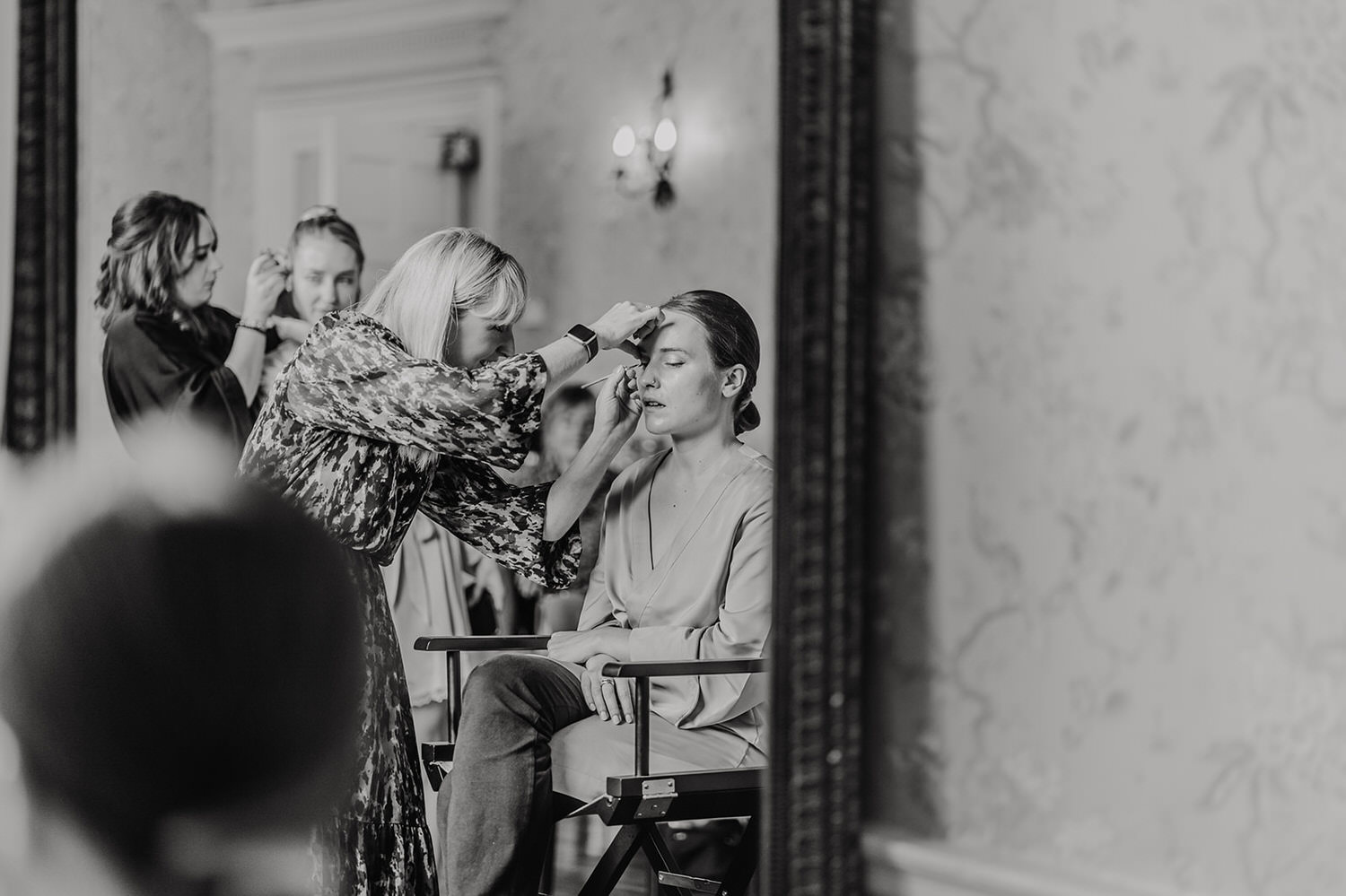 black and white photo of bridesmaid getting ready at morden hall wedding bridal prep