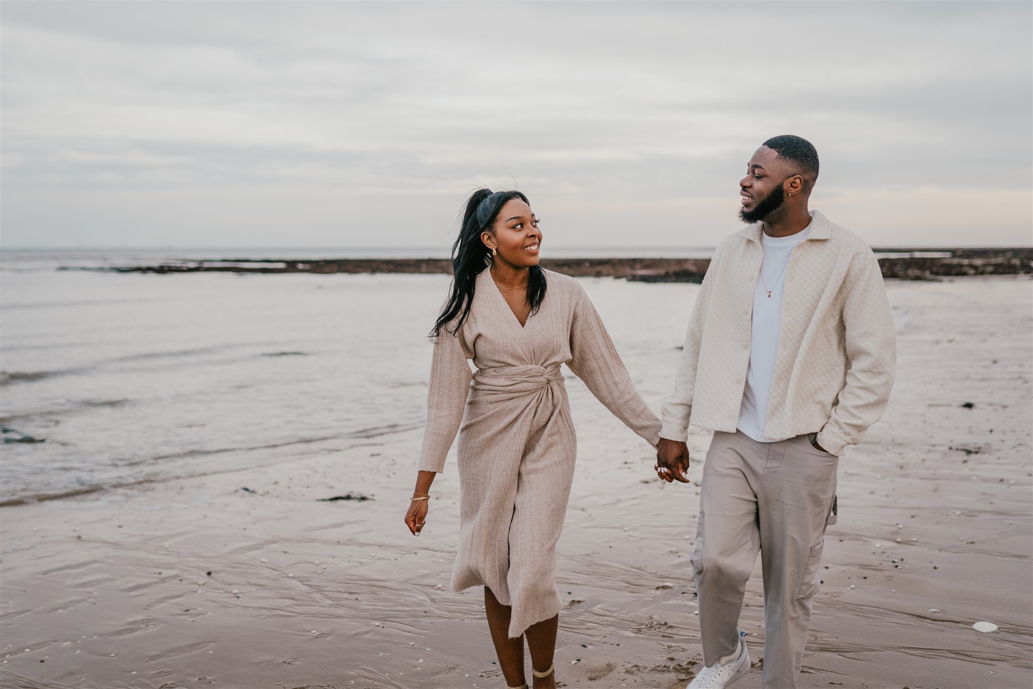 couple holding hands on the beach at botany bay couple shoot in kent