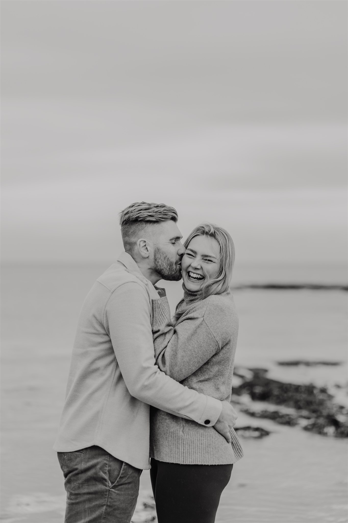 black and white image of couple embracing at botany bay beach in kent