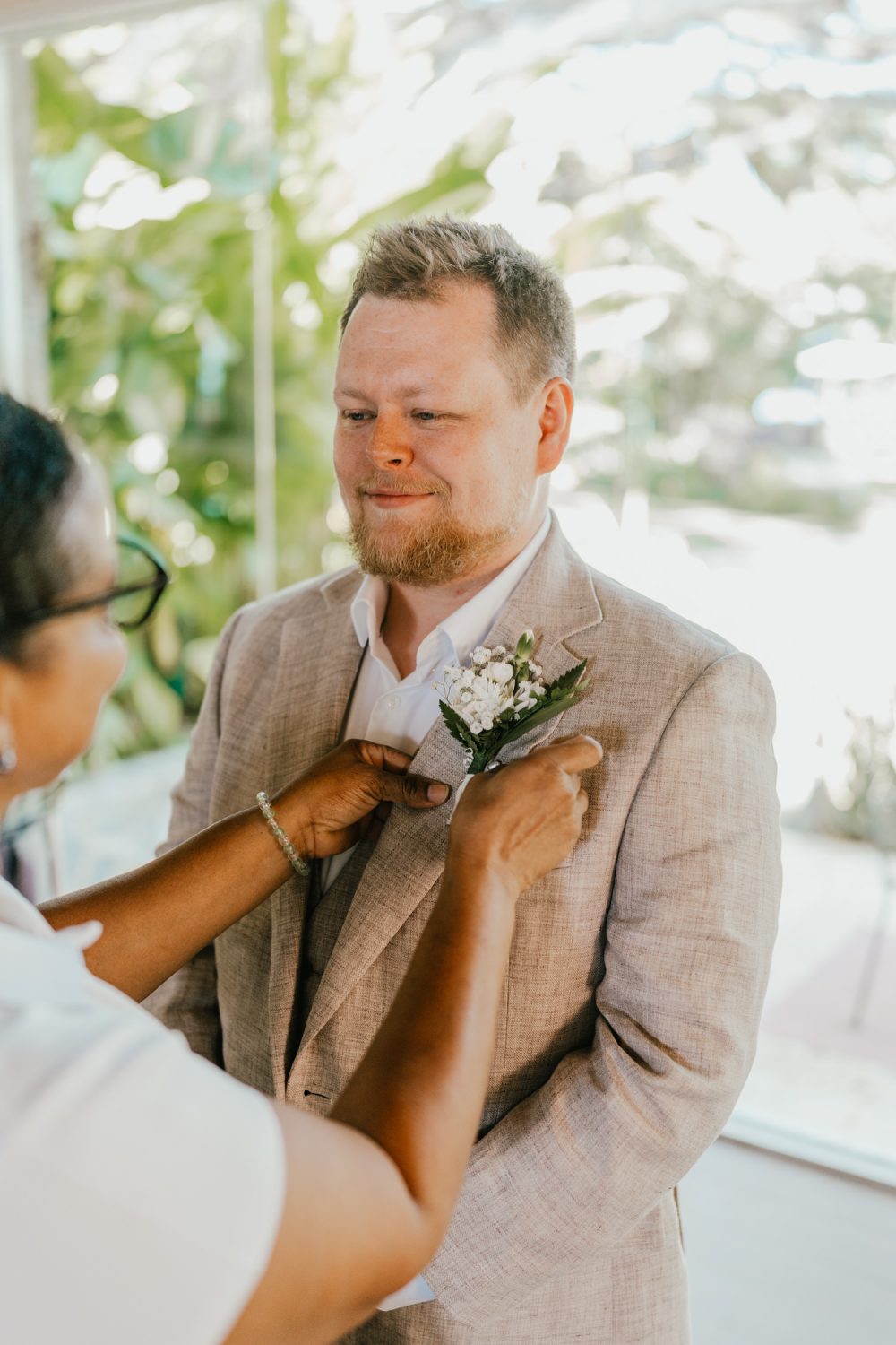 groom getting buttonhole attached for saint lucia elopement at stolentime resort