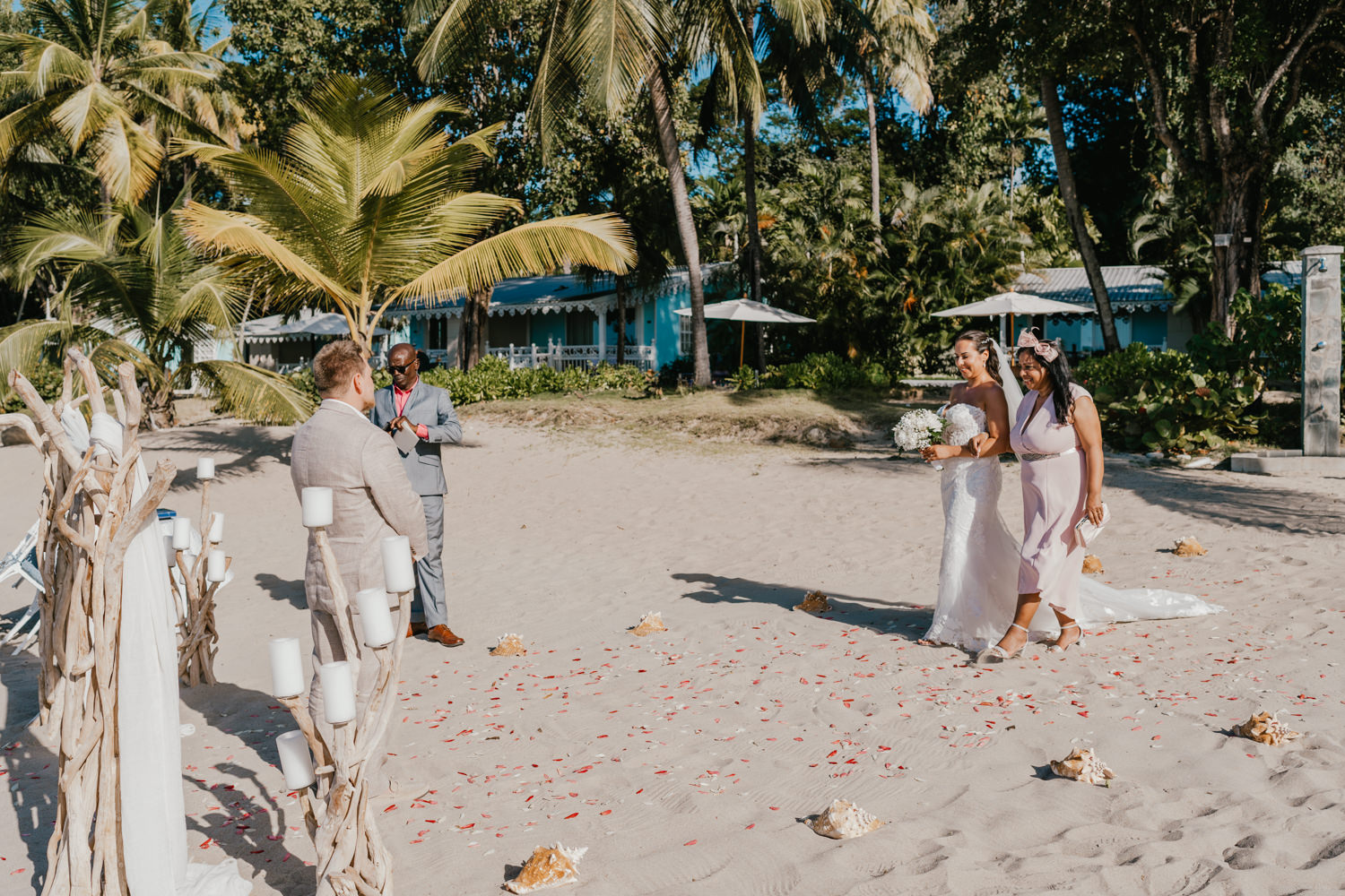 bride walks down the aisle with her mum during beach wedding ceremony at stolentime resort wedding venue in saint lucia