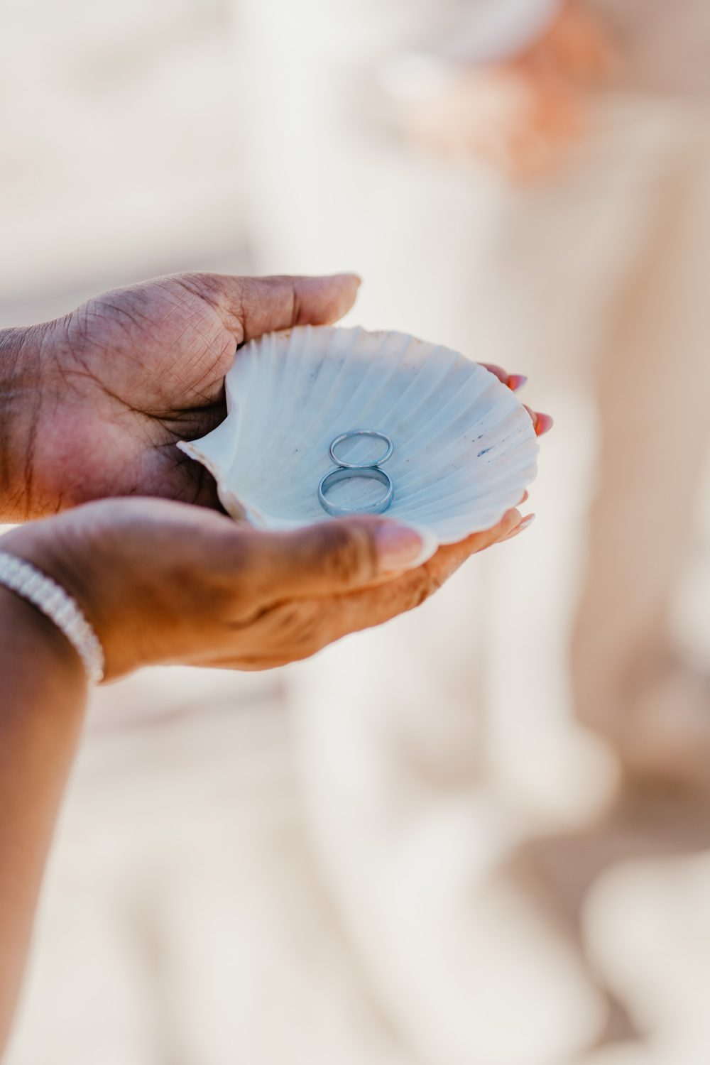 wedding rings in a shell being held by bride's mum during saint lucia wedding ceremony