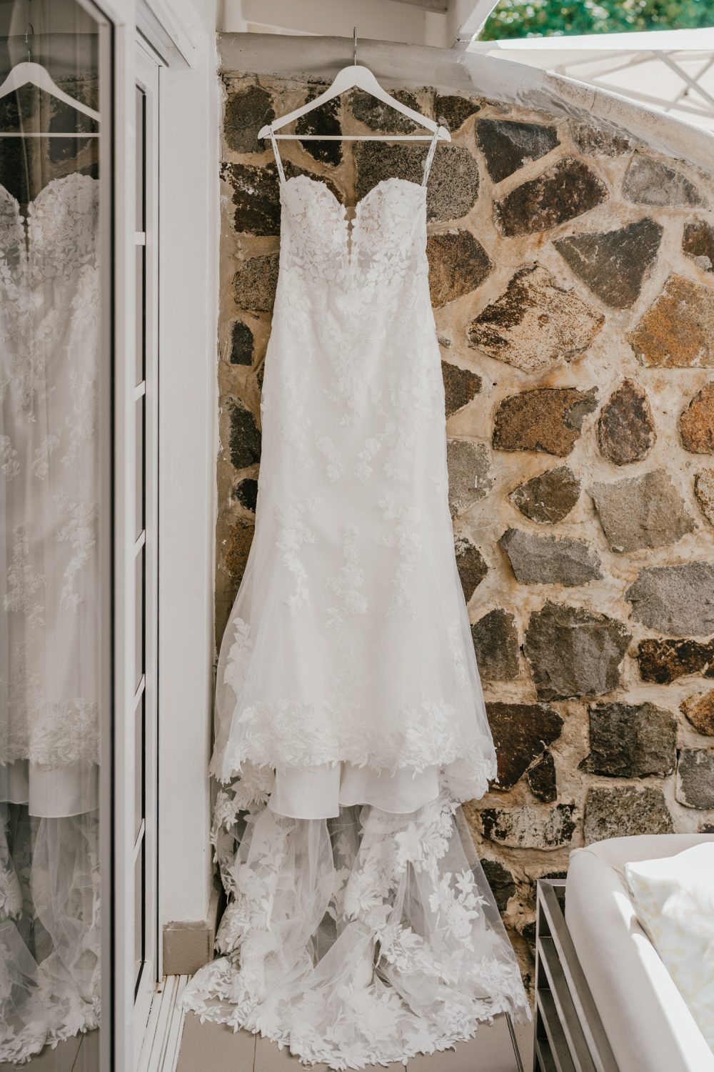 wedding dress hung outside against stone wall for caribbean destination wedding
