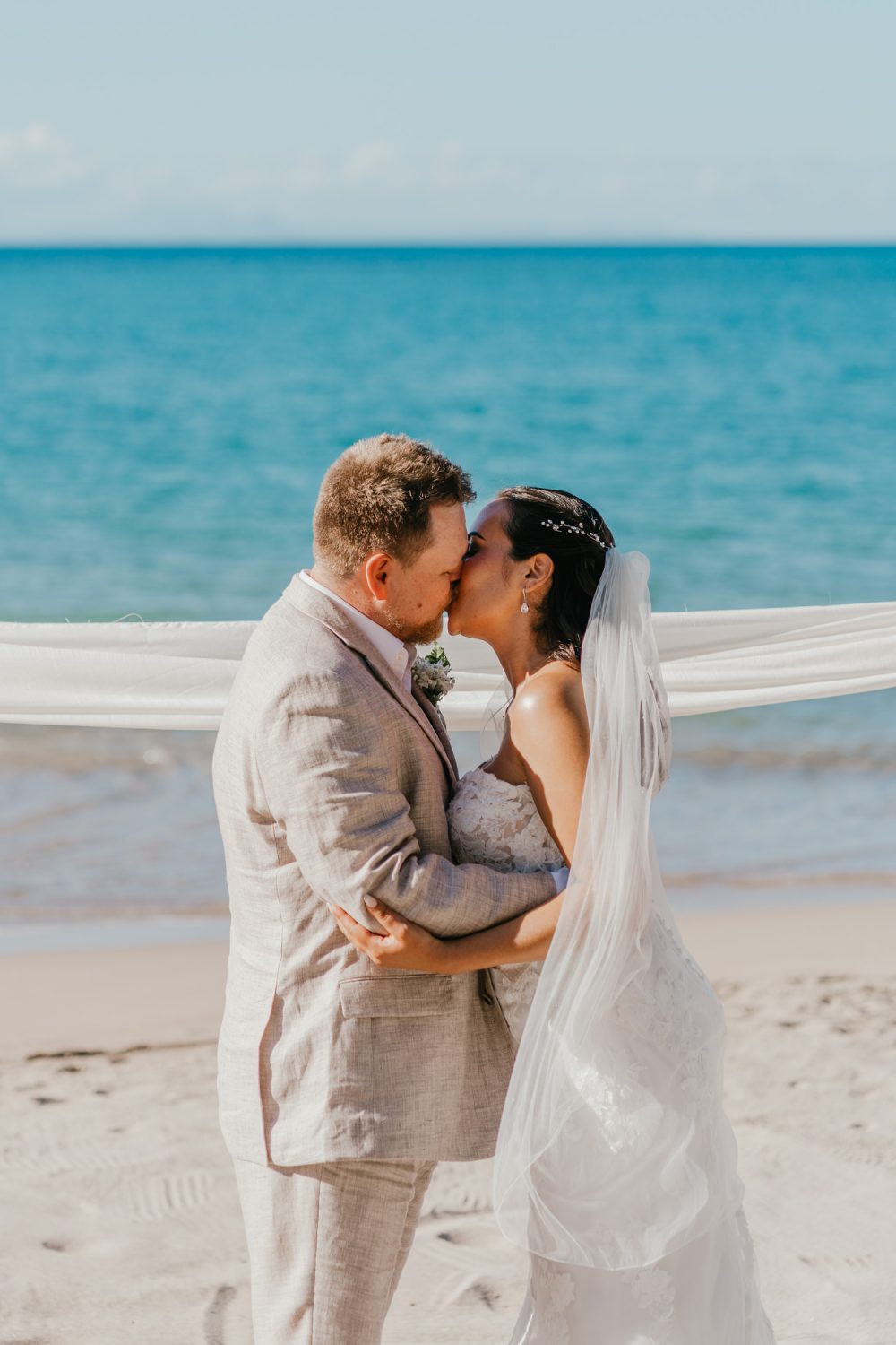 bride and groom first kiss during beach wedding ceremony for saint lucia elopement at stolentime resort wedding venue in the caribbean