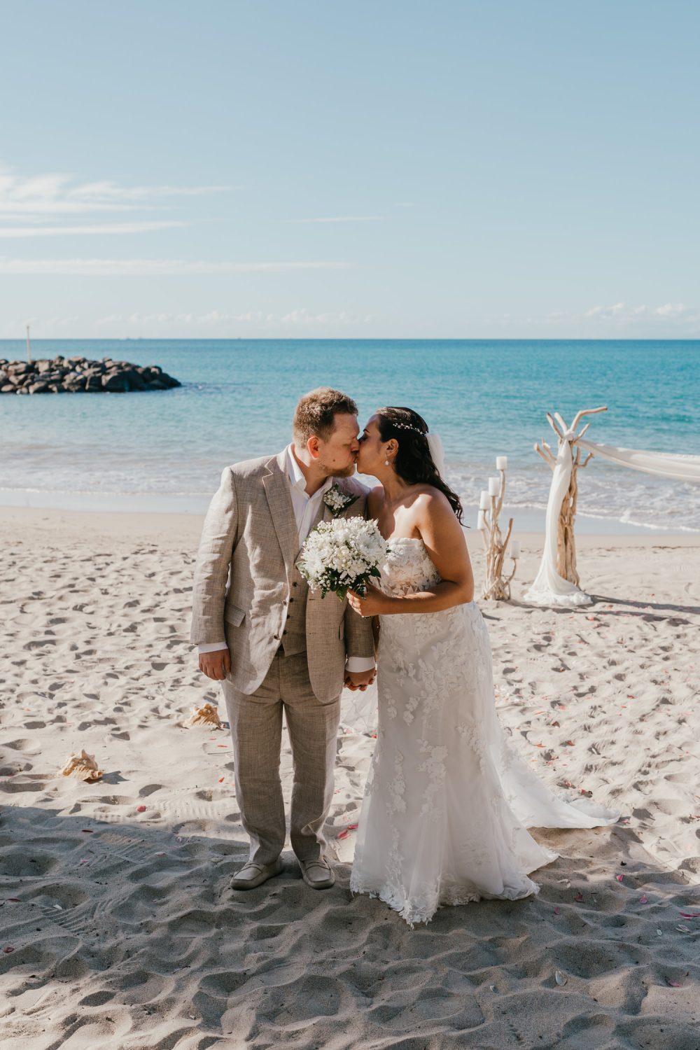 bride and groom kiss on the beach during their saint lucia elopement at stolentime resort wedding venue