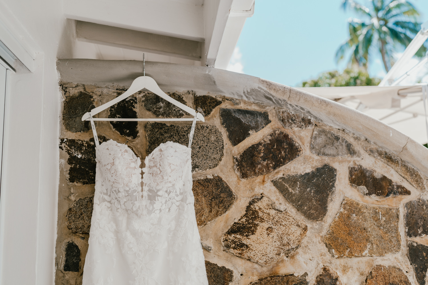wedding dress hung outside against stone wall for caribbean destination wedding