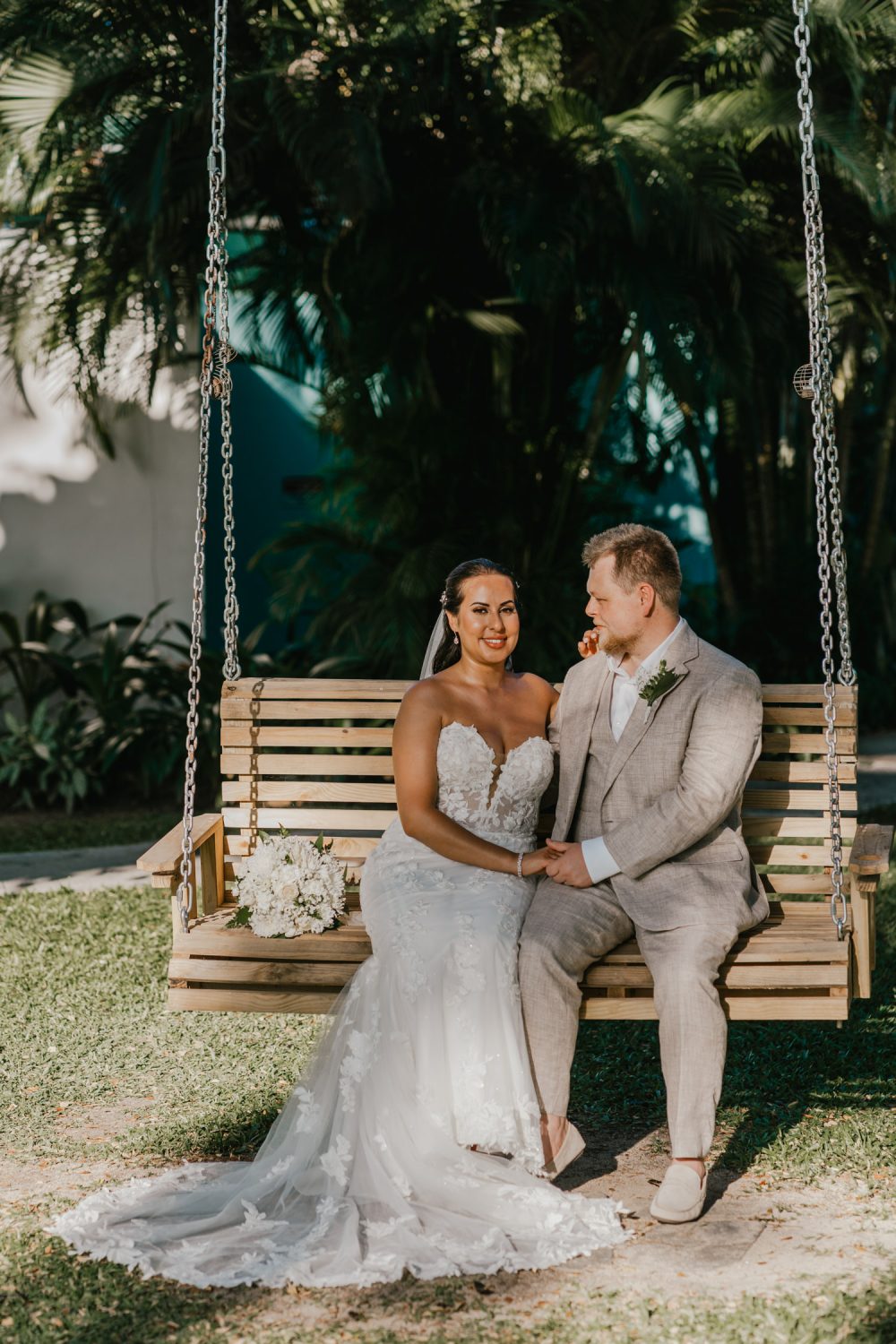 bride and groom sat on bench swing in the sun at stolentime resort saint lucia