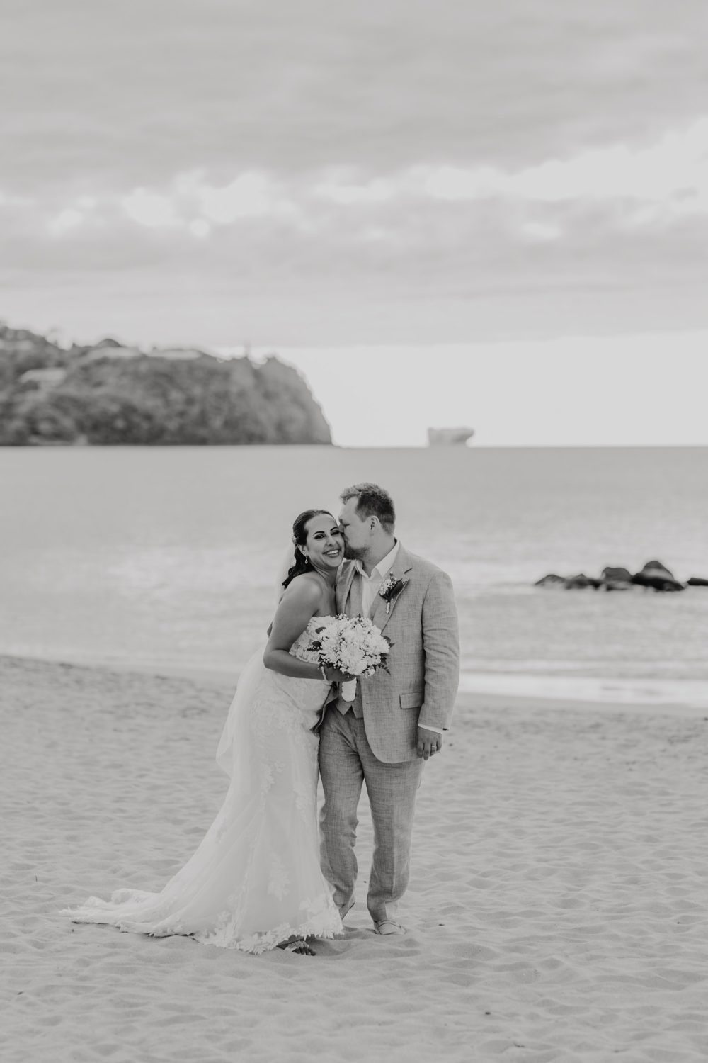 black and white image of bride and groom walking on the beach at stolentime resort during their saint lucia elopement
