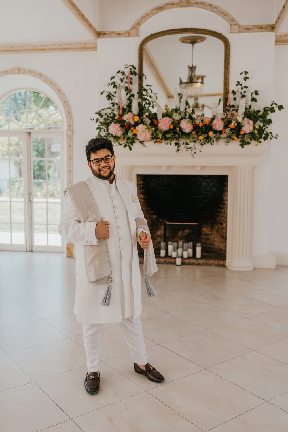groom portrait in front of the fireplace at northbrook park wedding