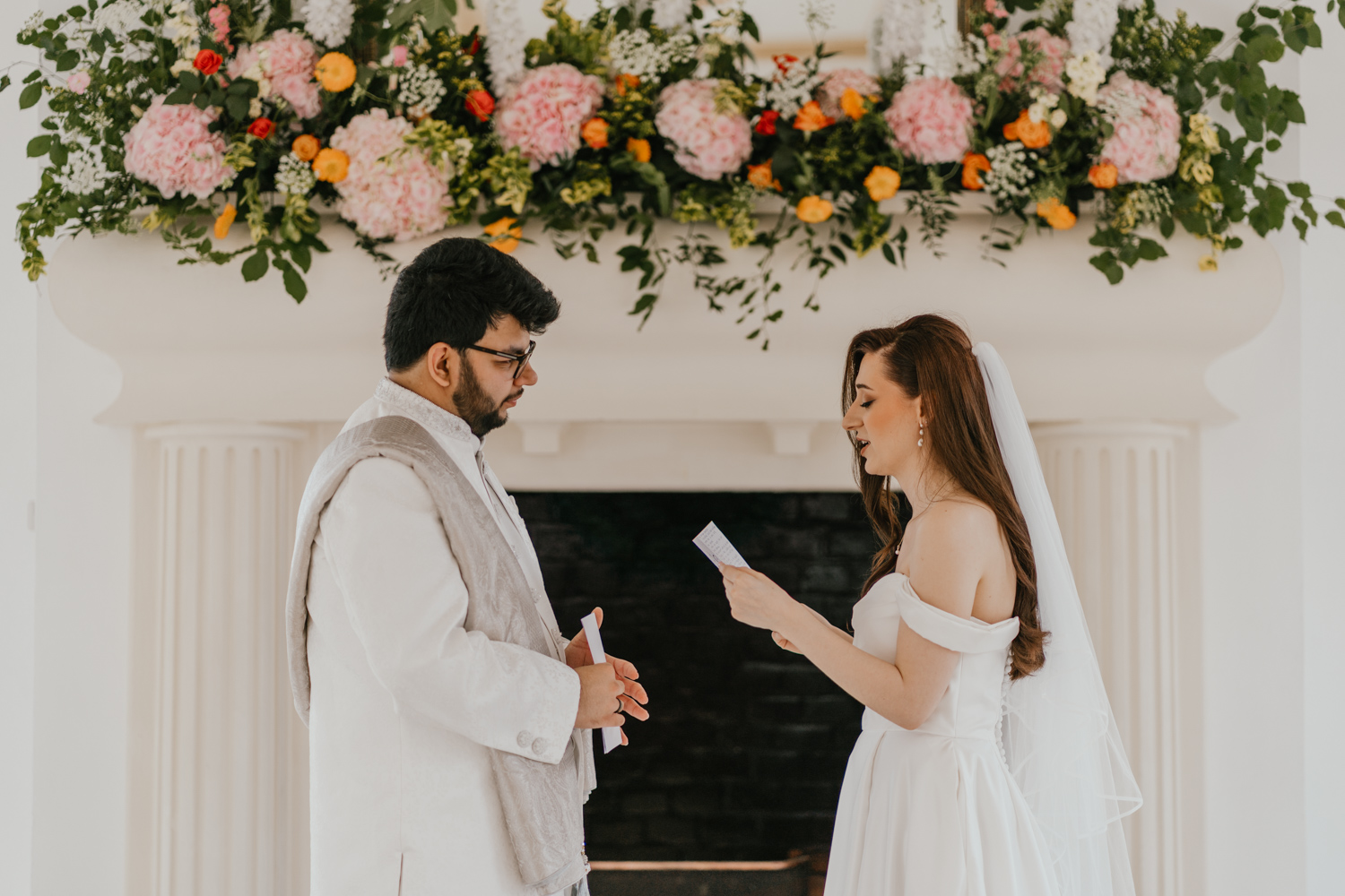 bride and groom exchange private vows during first look in front of the fireplace at northbrook park wedding venue