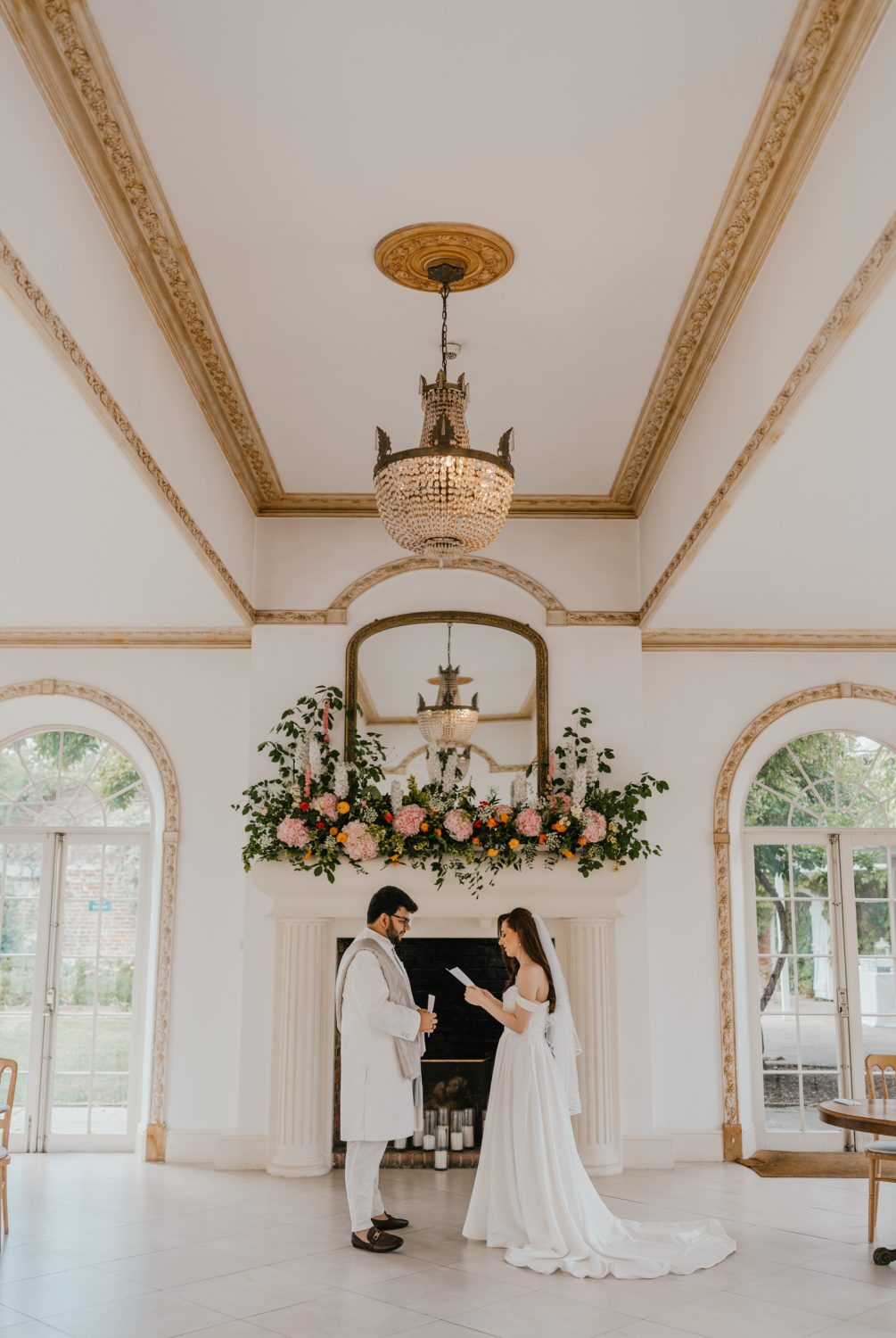 bride and groom exchange private vows during first look in front of the fireplace at northbrook park wedding venue