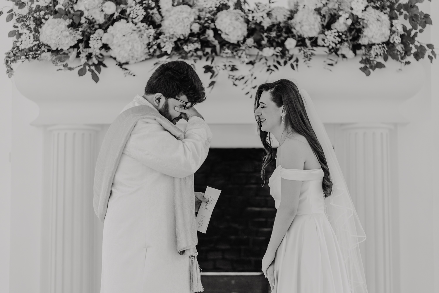 black and white image of bride and groom exchanging private vows during first look in front of the fireplace at northbrook park wedding venue