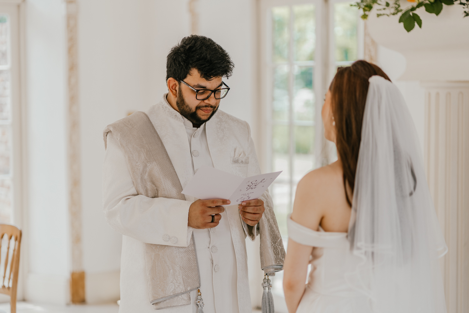 bride and groom exchange private vows during first look in front of the fireplace at northbrook park wedding venue
