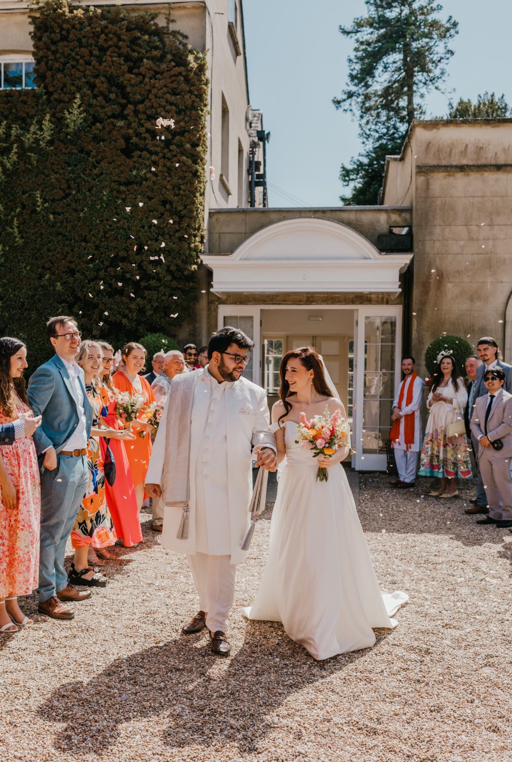 bride and groom walk through confetti tunnel after northbrook park wedding ceremony