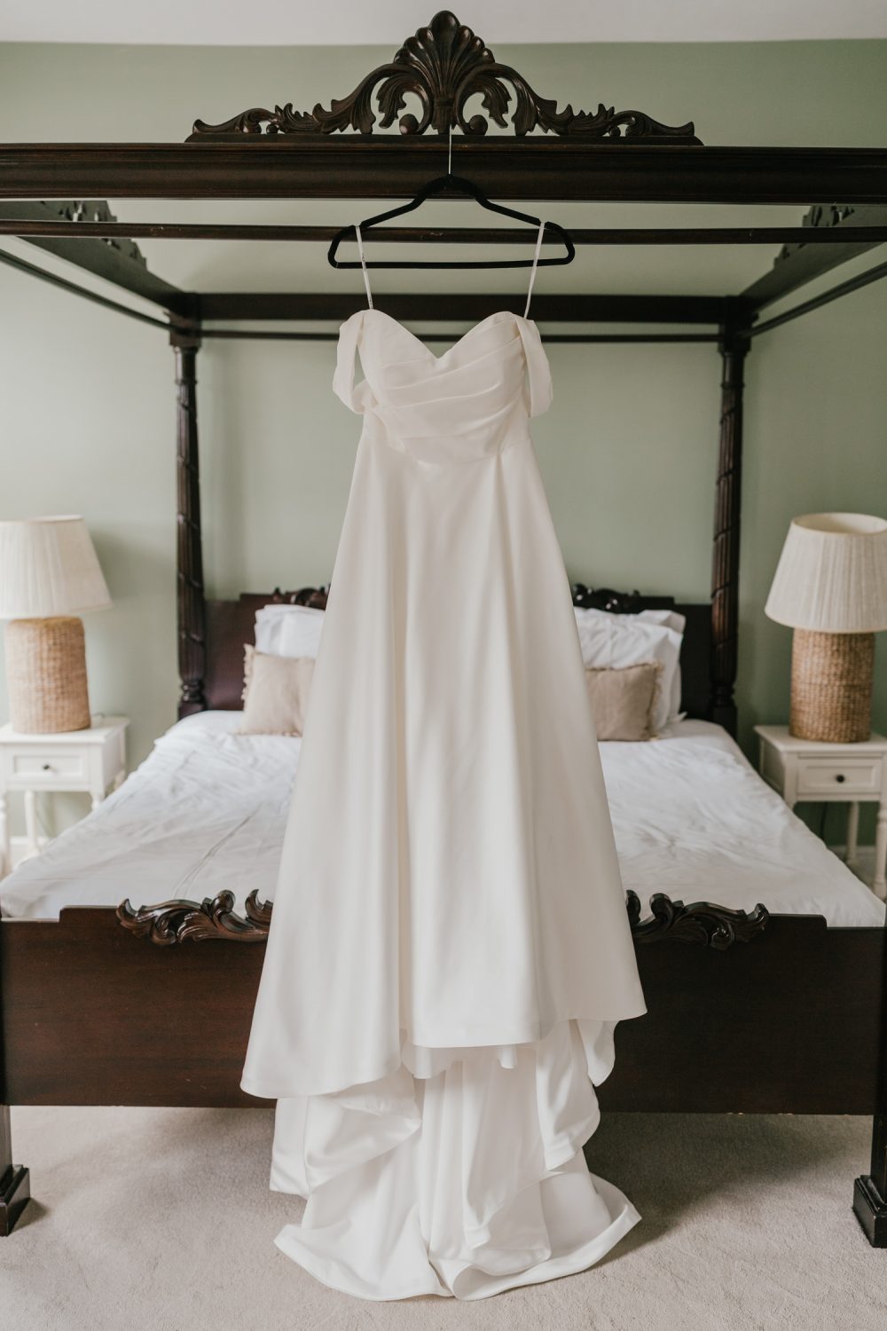 wedding dress hanging on four-poster bed at northbrook park
