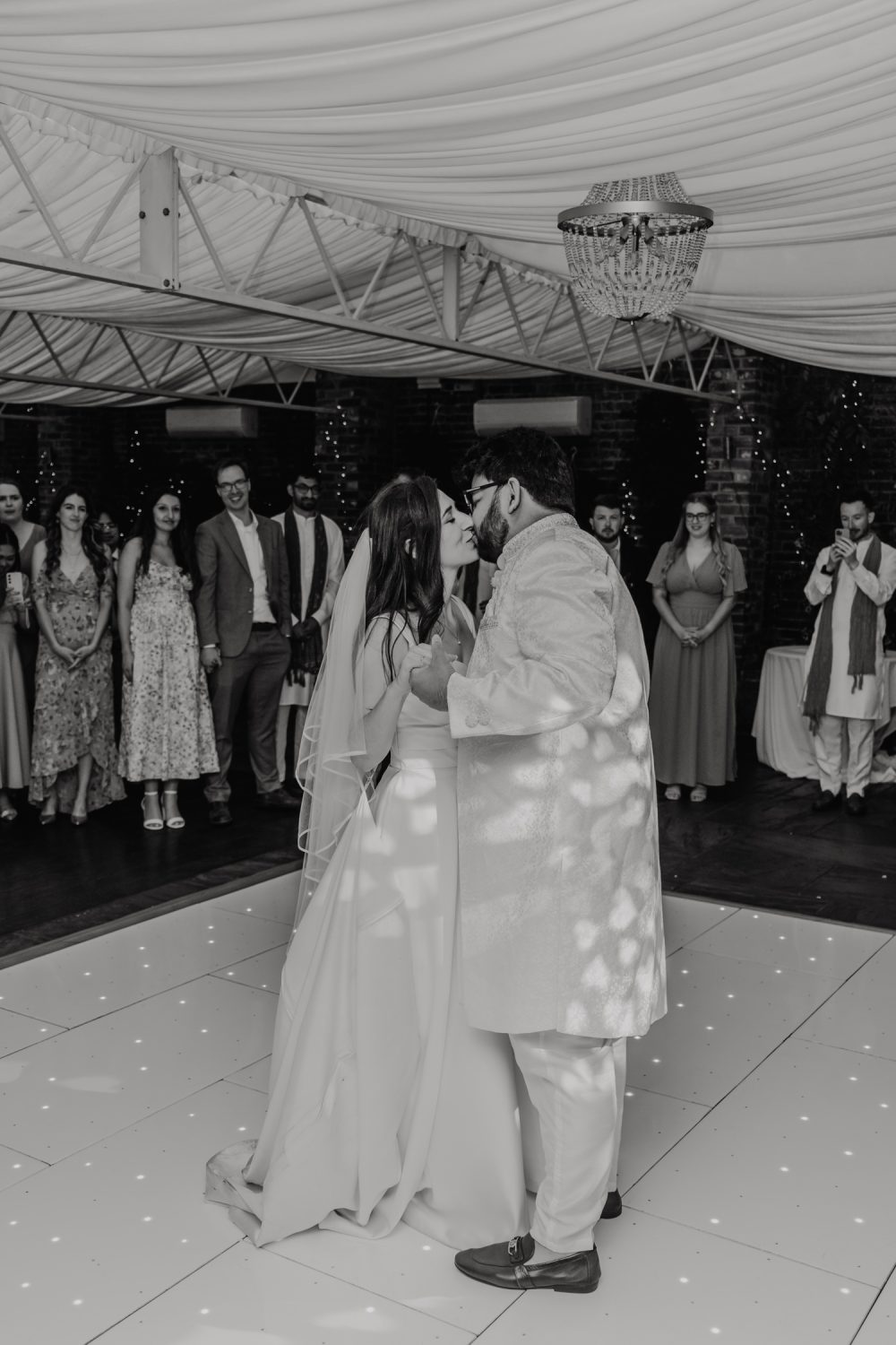 black and white photo of bride and groom kissing during first dance at northbrook park wedding venue in hampshire
