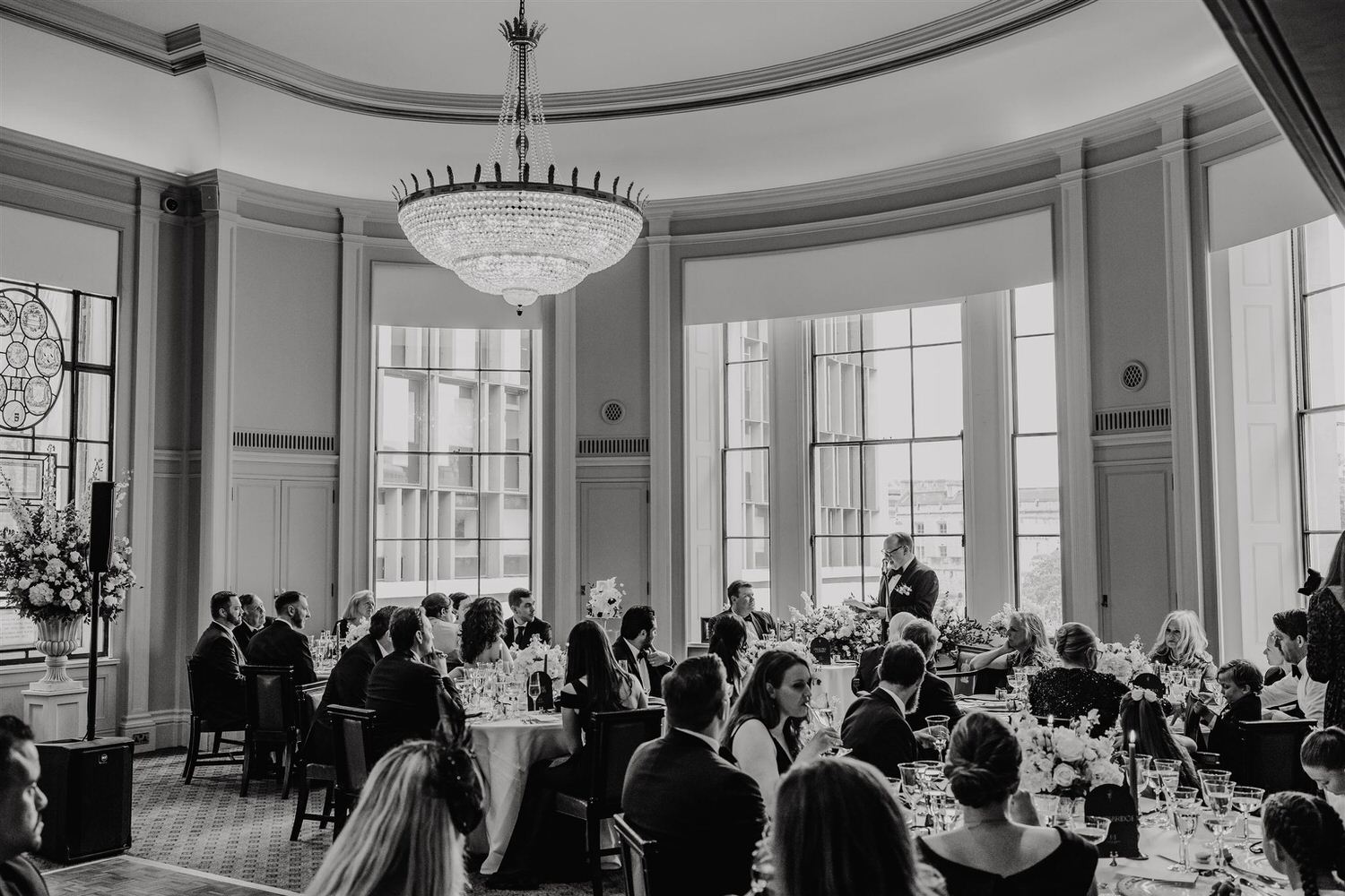 black and white photo of wedding speeches in the library at trinity house wedding venue in london