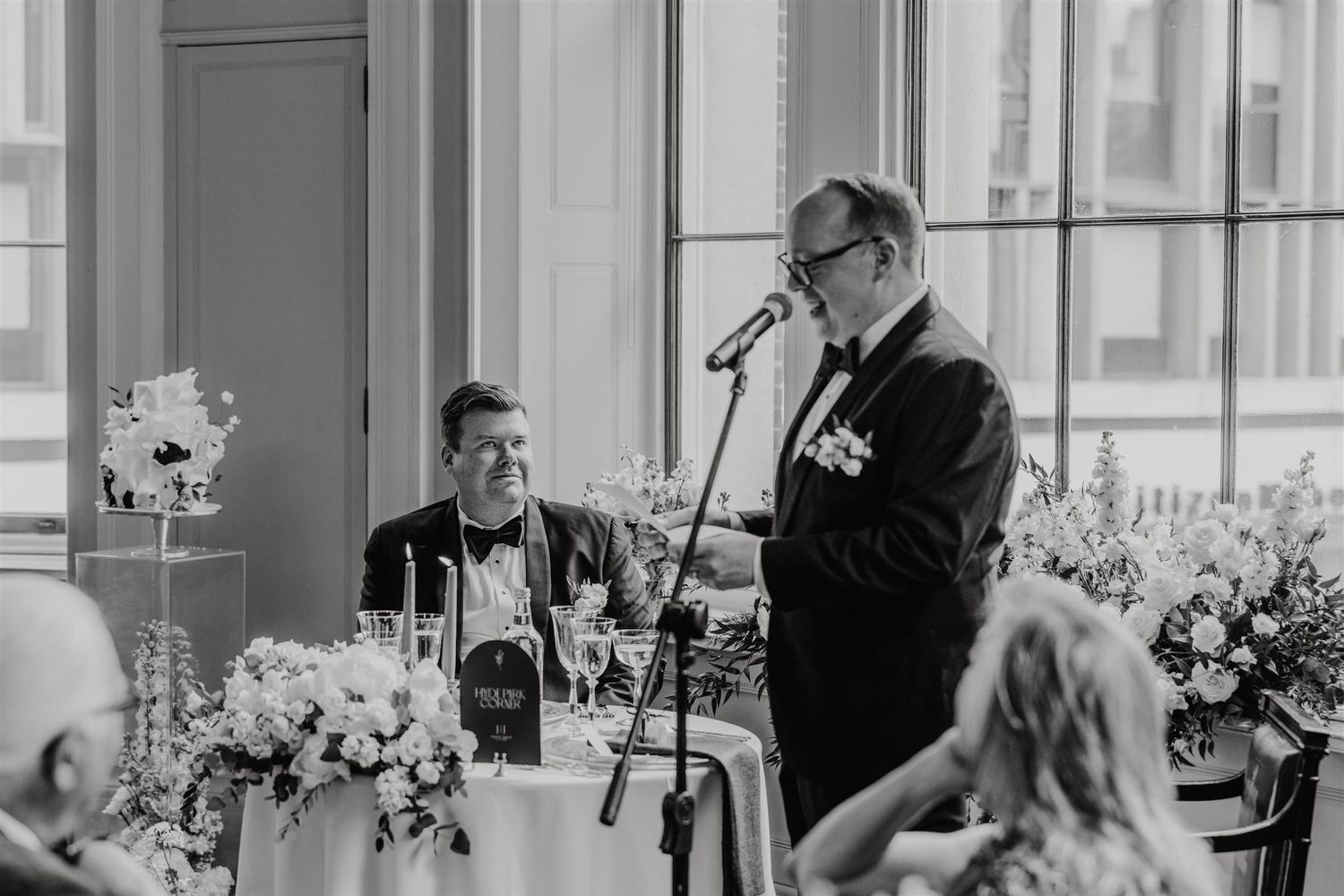 black and white photo of wedding speeches in the library at trinity house wedding venue in london
