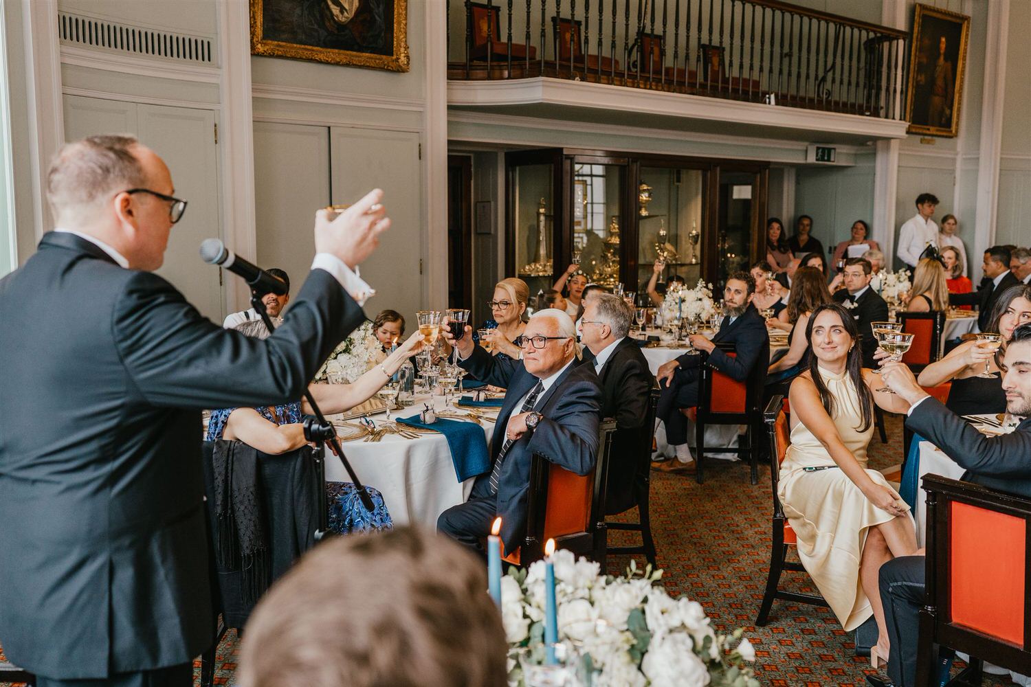 wedding guests reaction to speeches in the library at trinity house wedding venue in london