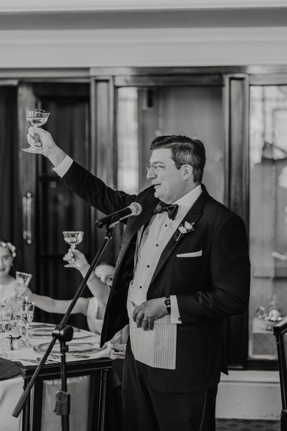 black and white photo of best man's speech in the library at trinity house wedding venue in london