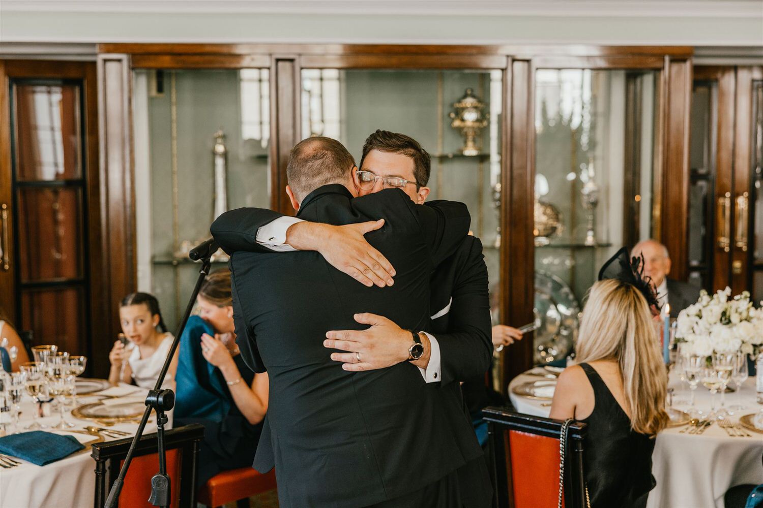 groom hugging best man after speech in the library at trinity house wedding venue in london