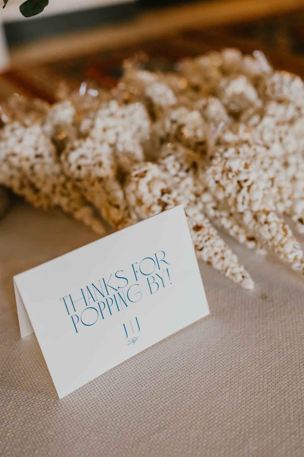 popcorn wedding favours on a table and sign that reads thanks for popping by