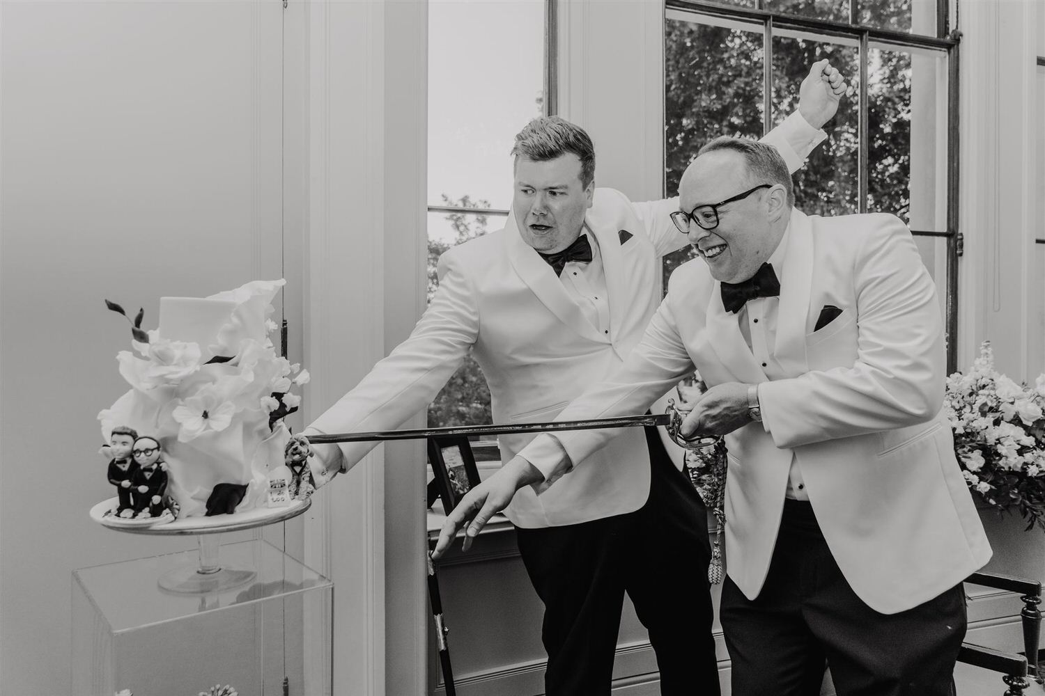 black and white photo of grooms cutting wedding cake at trinity house wedding in london