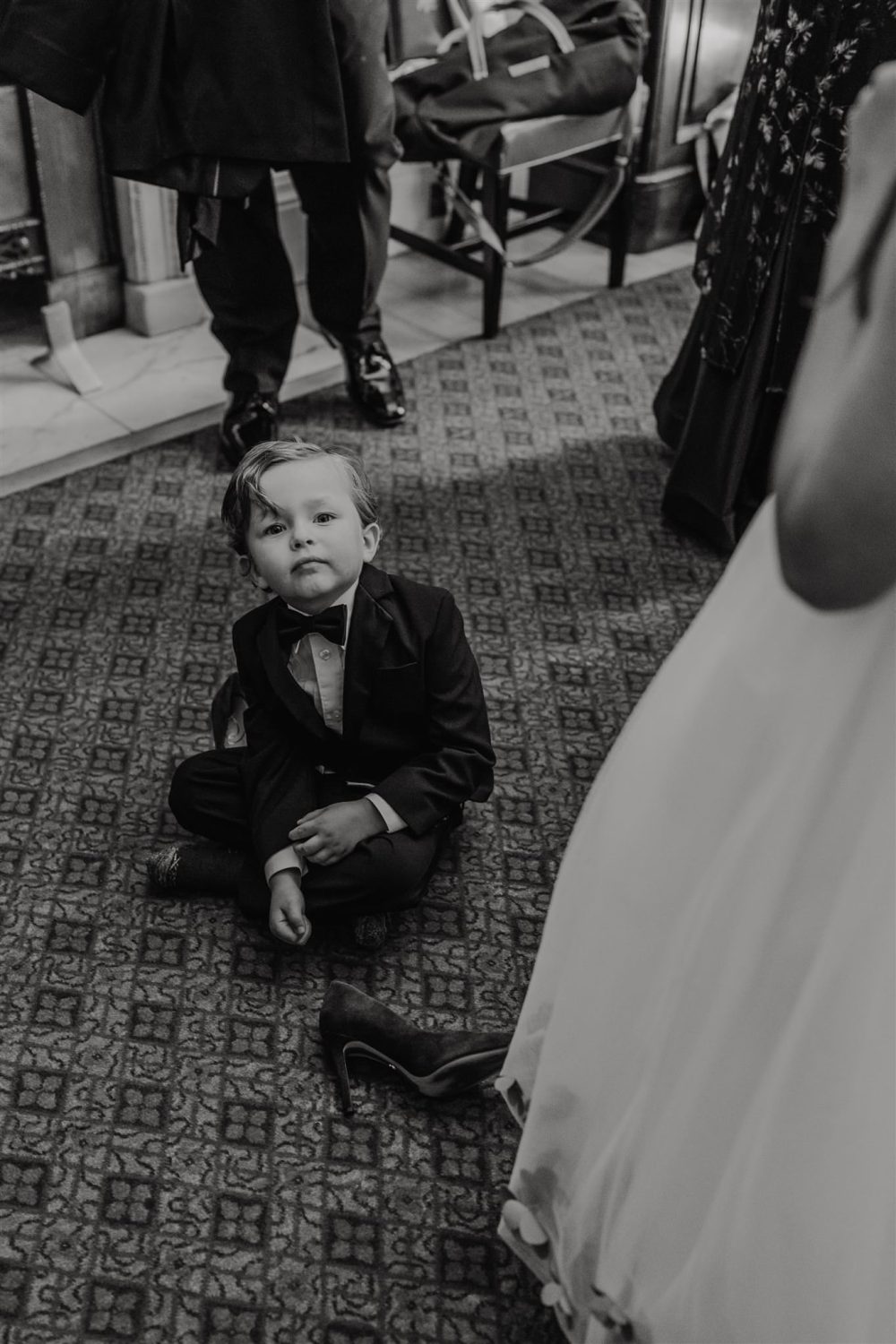 black and white photo of ring bearer getting ready at trinity house london wedding