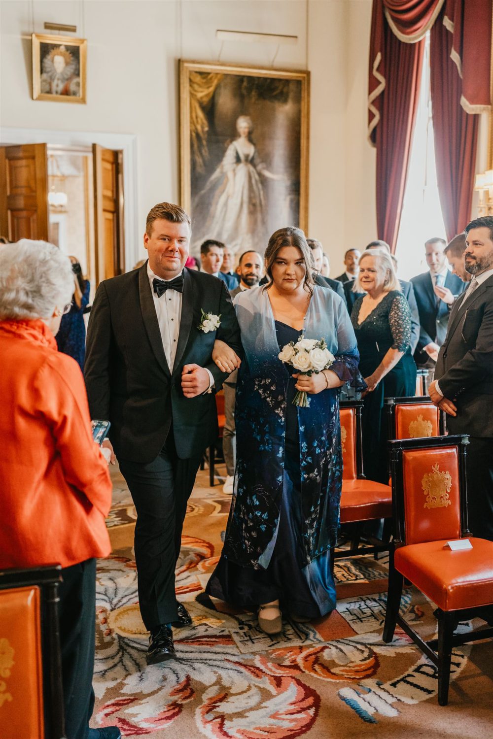 groom walking down the aisle with his sister at trinity house london wedding