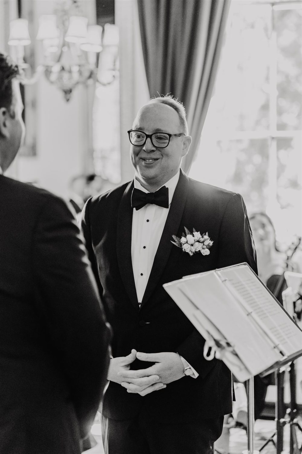 black and white photo of groom standing at the altar during trinity house wedding ceremony in the court room
