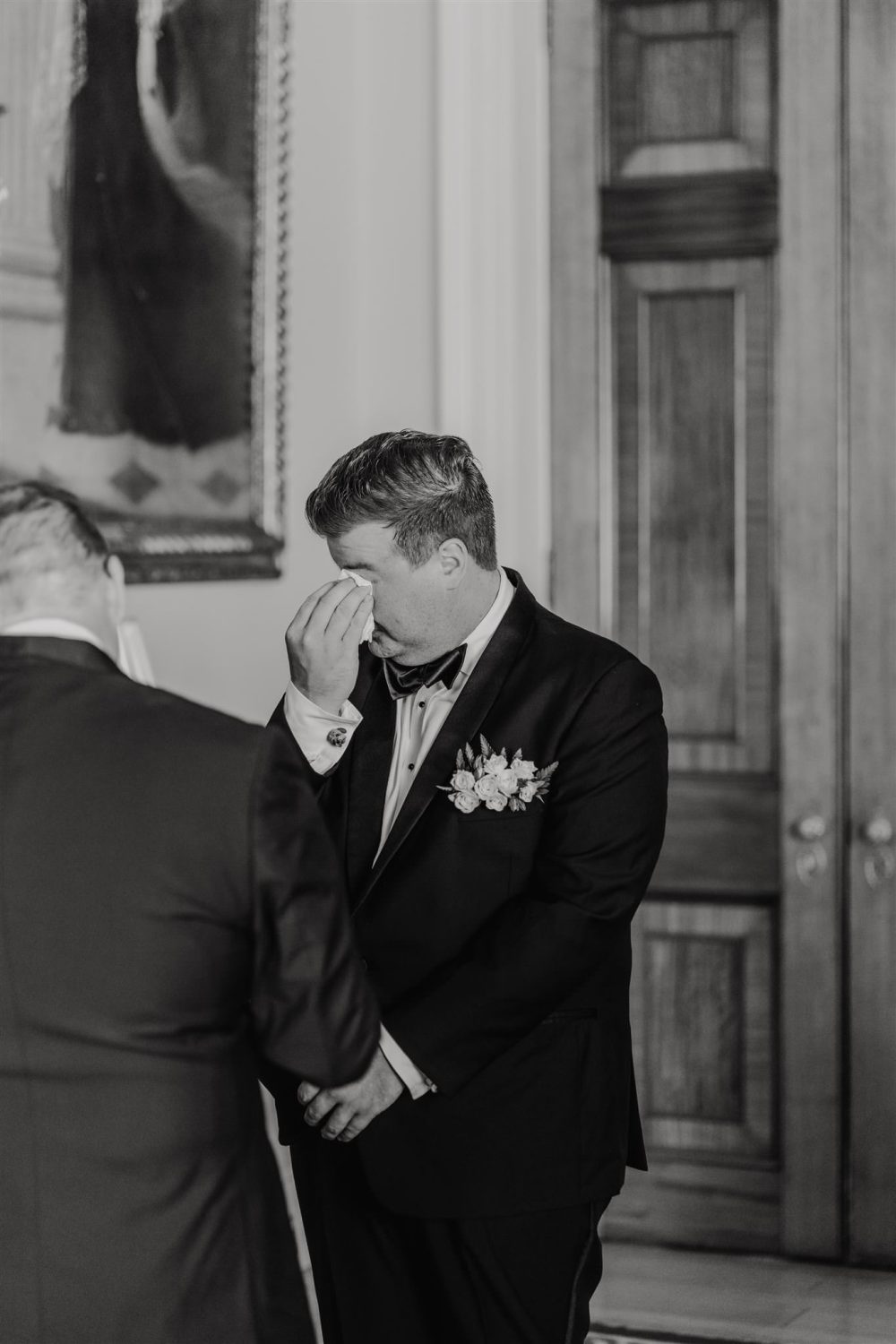 black and white photo of groom crying at the altar during trinity house wedding ceremony in the court room