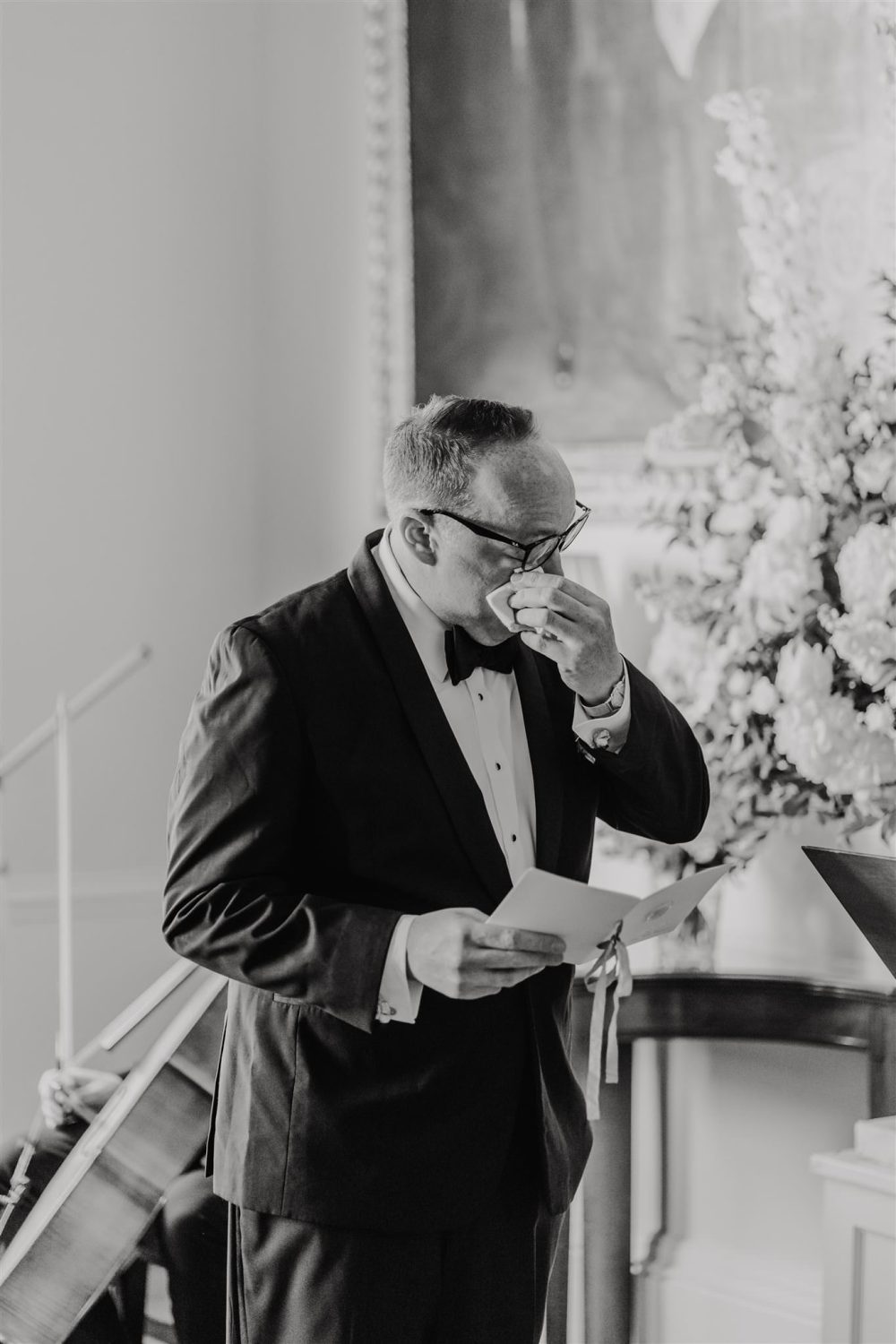 black and white photo of groom crying whilst reading vows during trinity house wedding ceremony in the court room